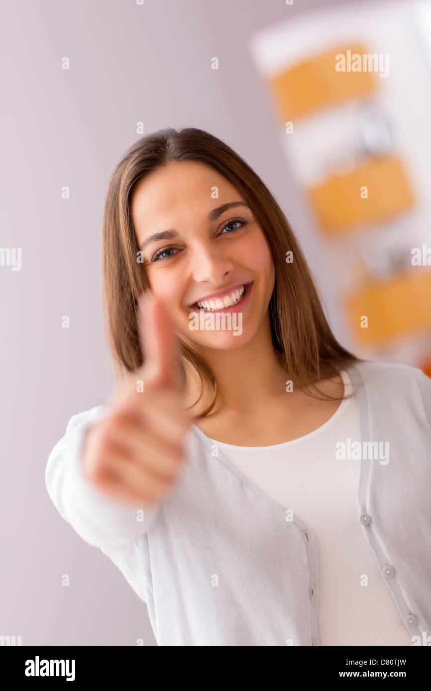 Immagine luminosa della giovane donna con il pollice in alto Foto Stock