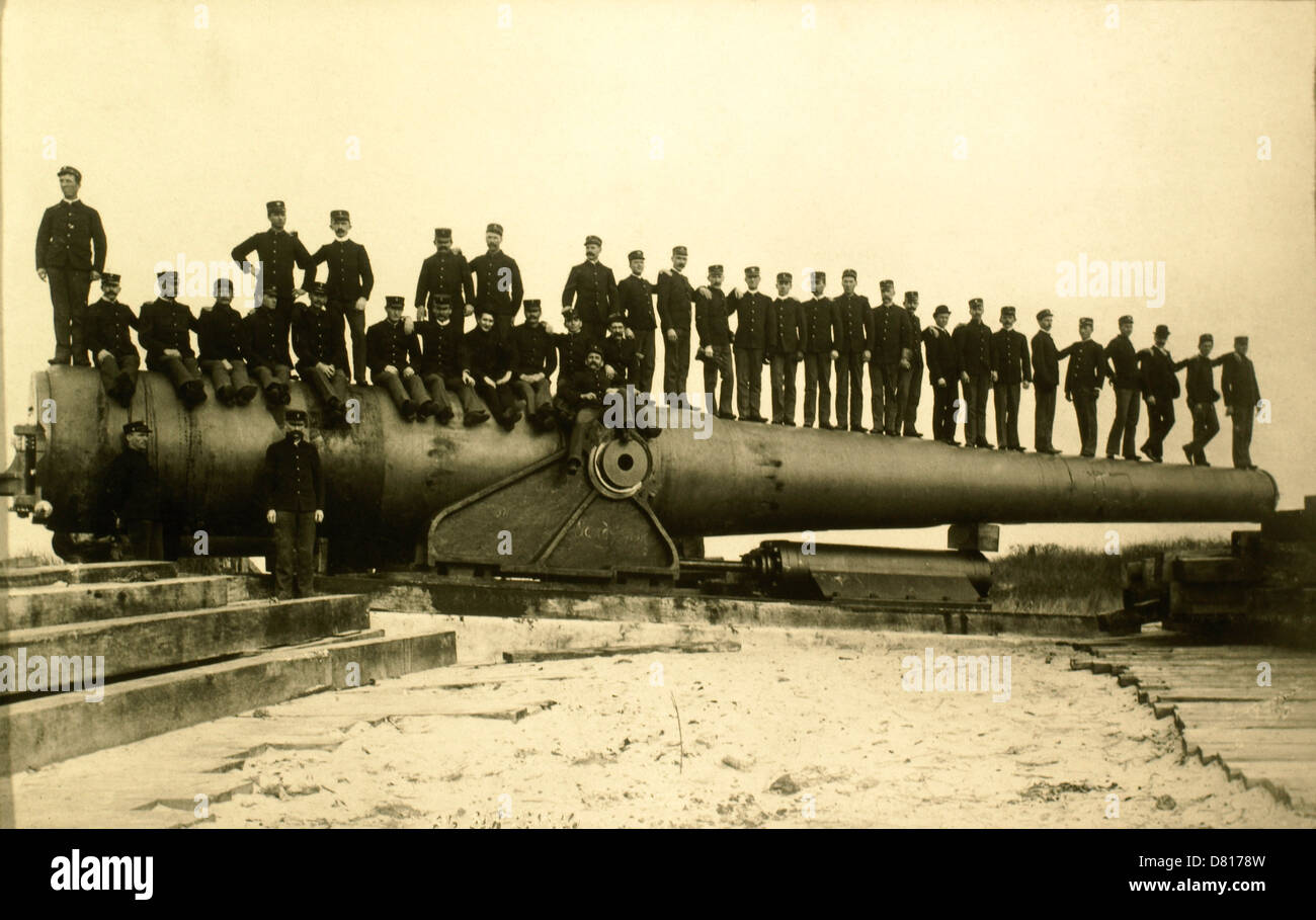 Un gruppo di uomini seduti sulla canna di grandi Railroad pistola, WWI, circa 1910's Foto Stock
