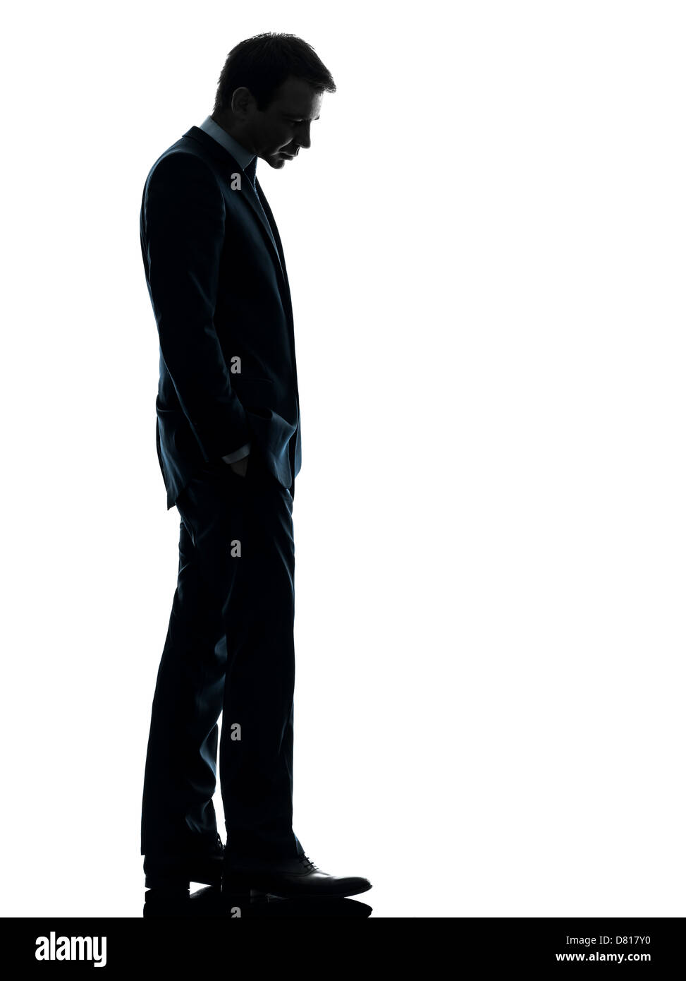 Una triste business man guardando giù in silhouette studio isolato su sfondo bianco Foto Stock