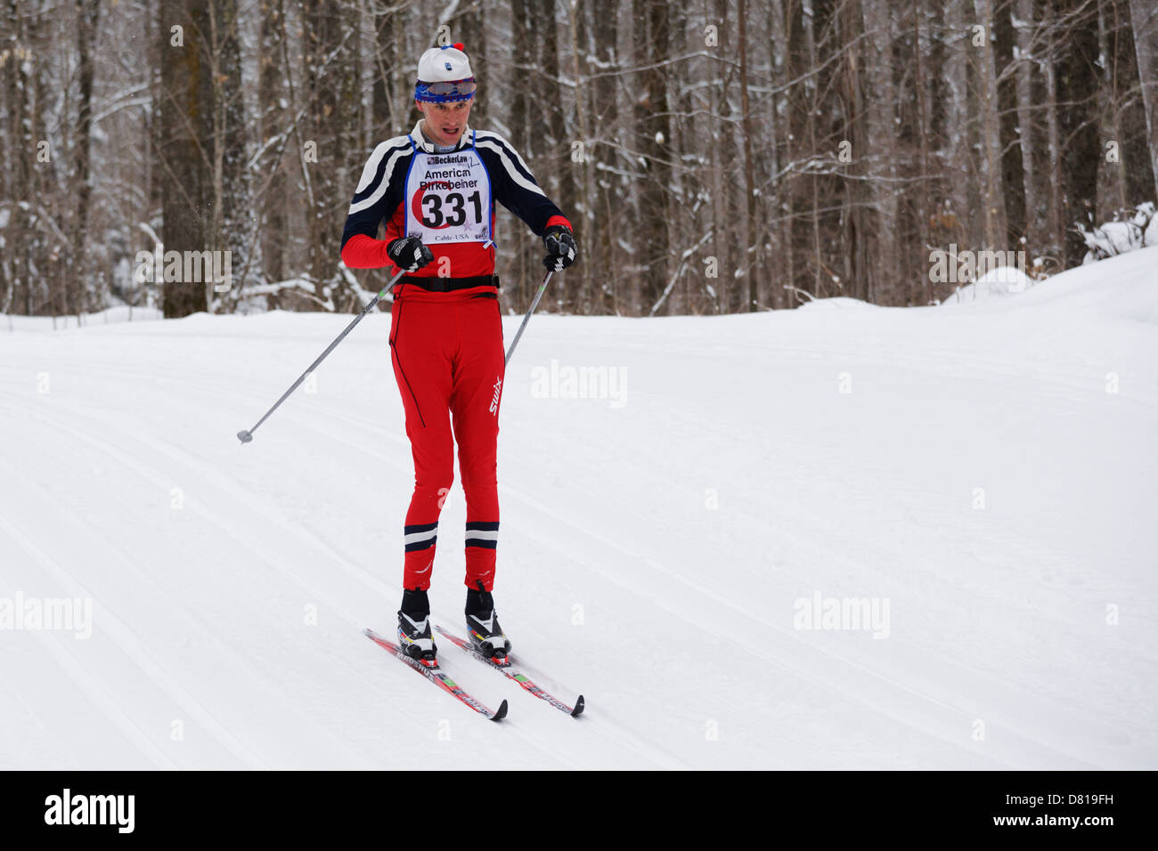 Stile classico sciatore Owen Baird sul sentiero tra cavo e Hayward, Wisconsin durante l'American Birkebeiner. Foto Stock