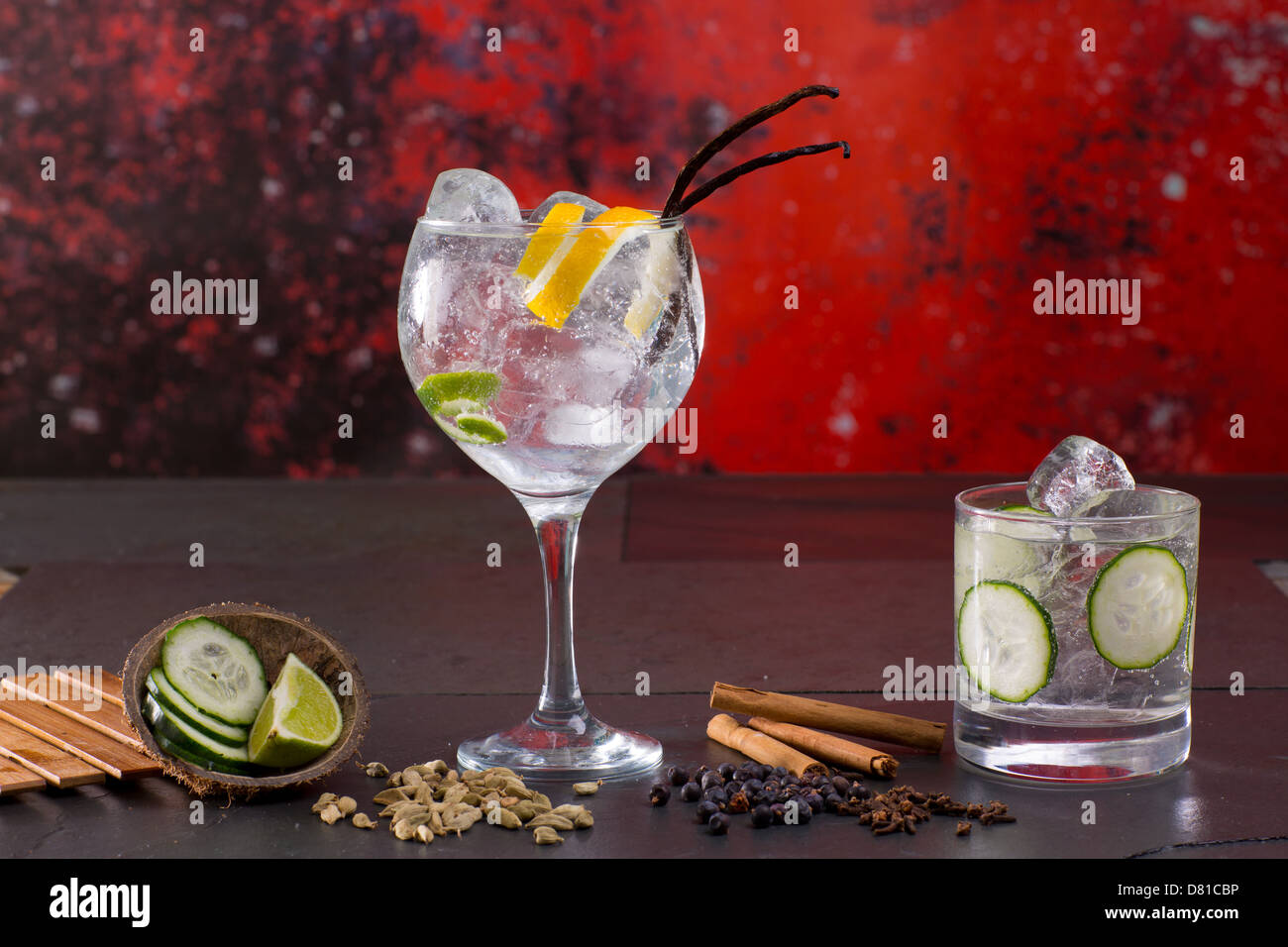 Il gin tonic cocktail con spezie lima cetriolo Vaniglia Chiodi di garofano  cardamomo cannella e bacche di ginepro in rosso Foto stock - Alamy