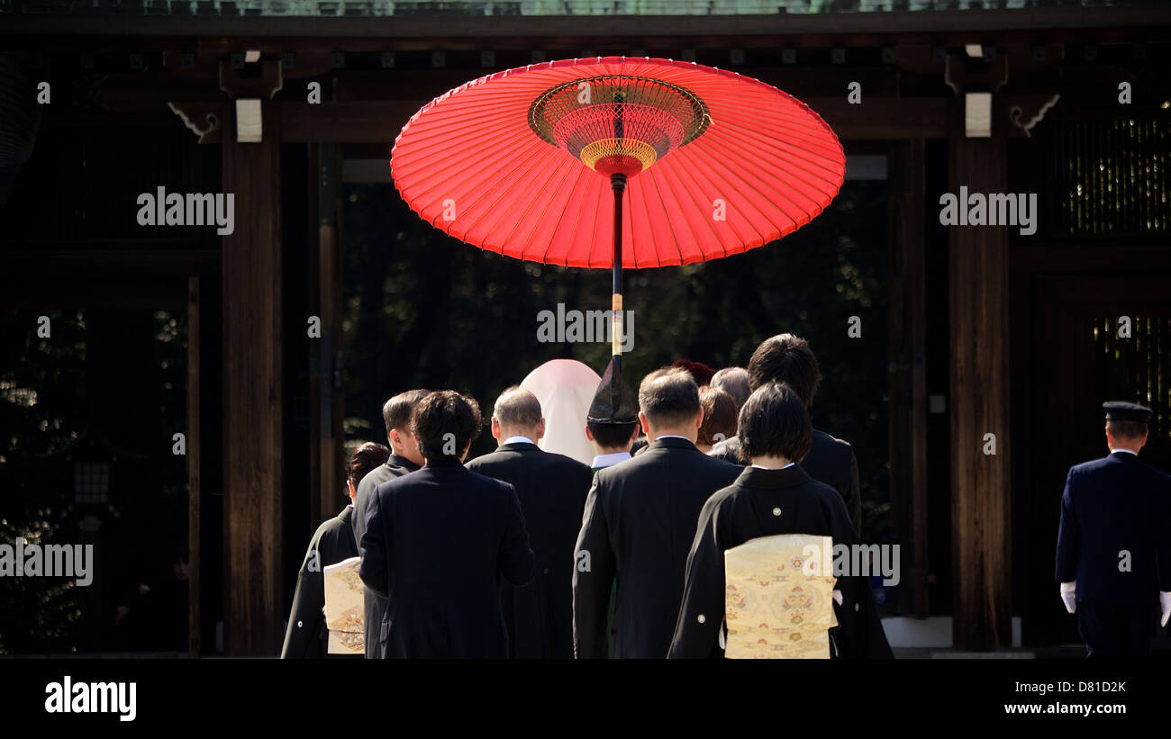 Giapponese Shinto Tradizionale Matrimonio al Tempio di Meiji con colore rosso brillante Gifu Ombrellone e entourage di amici e familiari Foto Stock