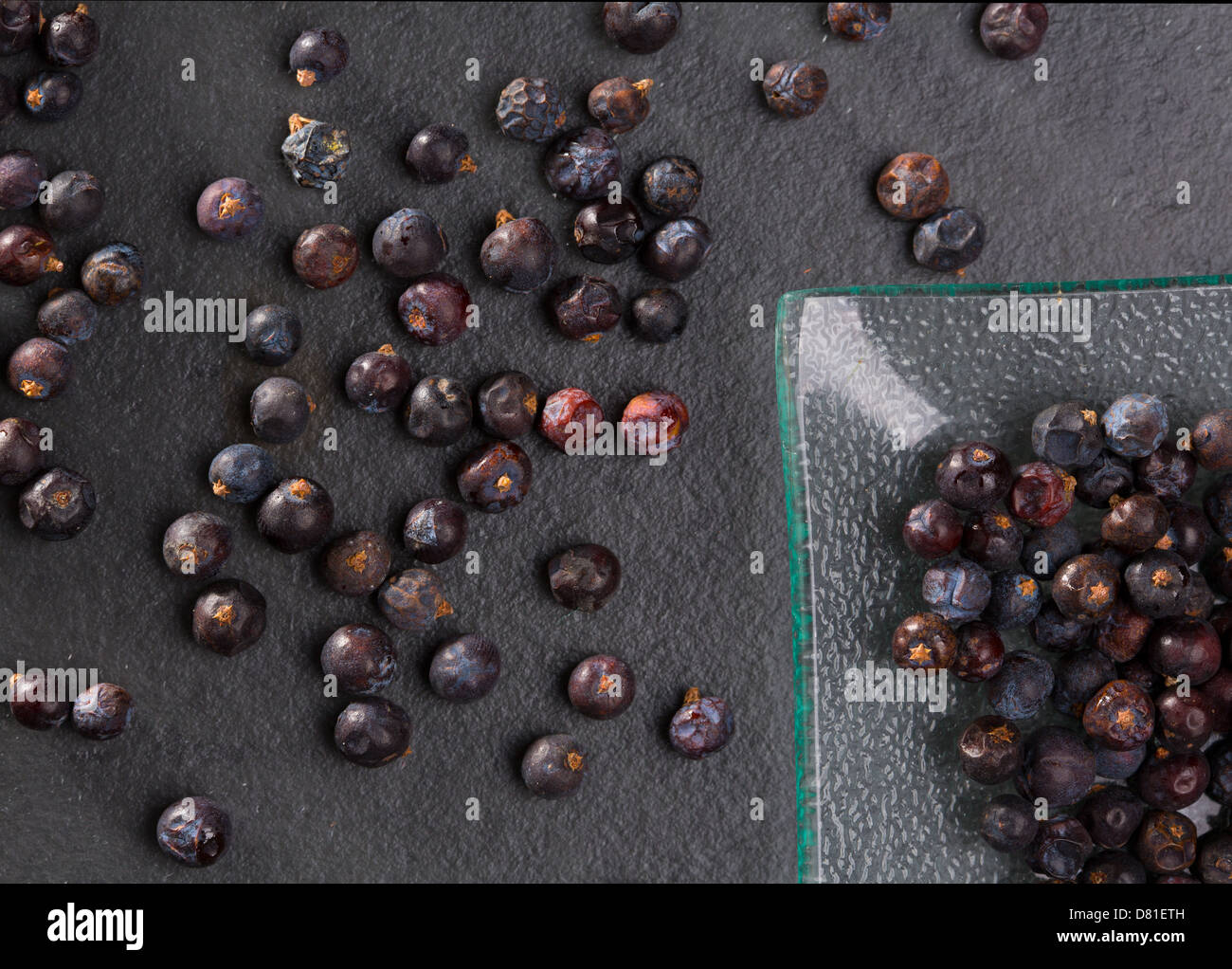Bacche di ginepro dettaglio macro closeup su ardesia nera sullo sfondo di pietra Foto Stock