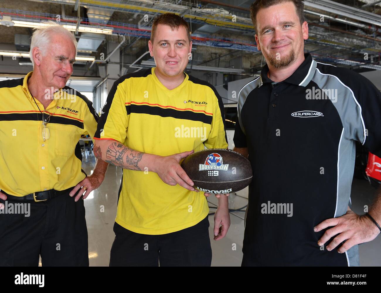 Austin, TX, Stati Uniti Maggio 16, 2013. I membri dell'equipaggio di Dunlop sport a motore posano con una palla utilizzata in Australian Football League nel garage della cota di Austin, TX. Credito: Cal Sport Media /Alamy Live News Foto Stock
