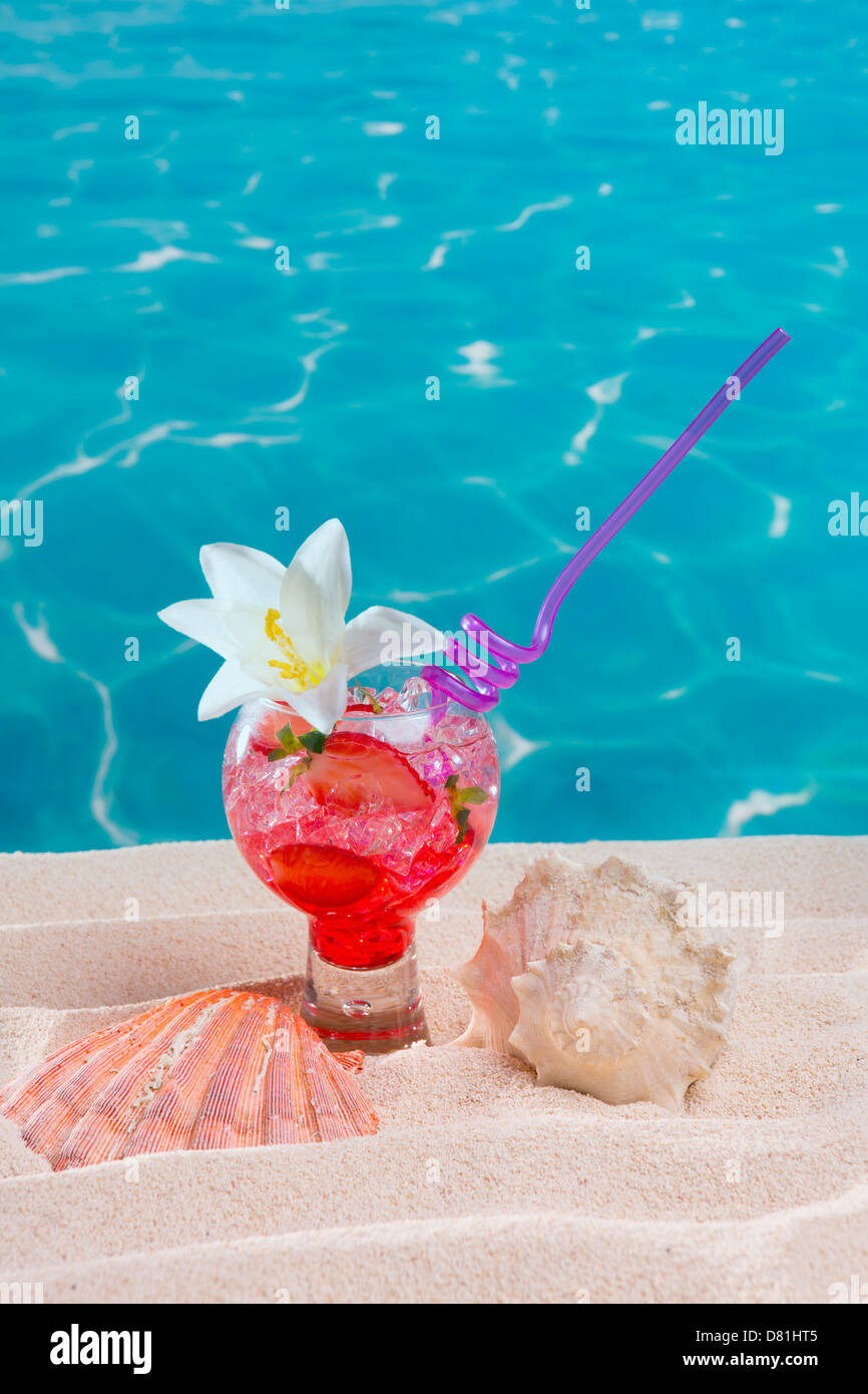 Spiaggia tropicale cocktail rosso su bianco dei caraibi fiore di sabbia e conchiglia Foto Stock