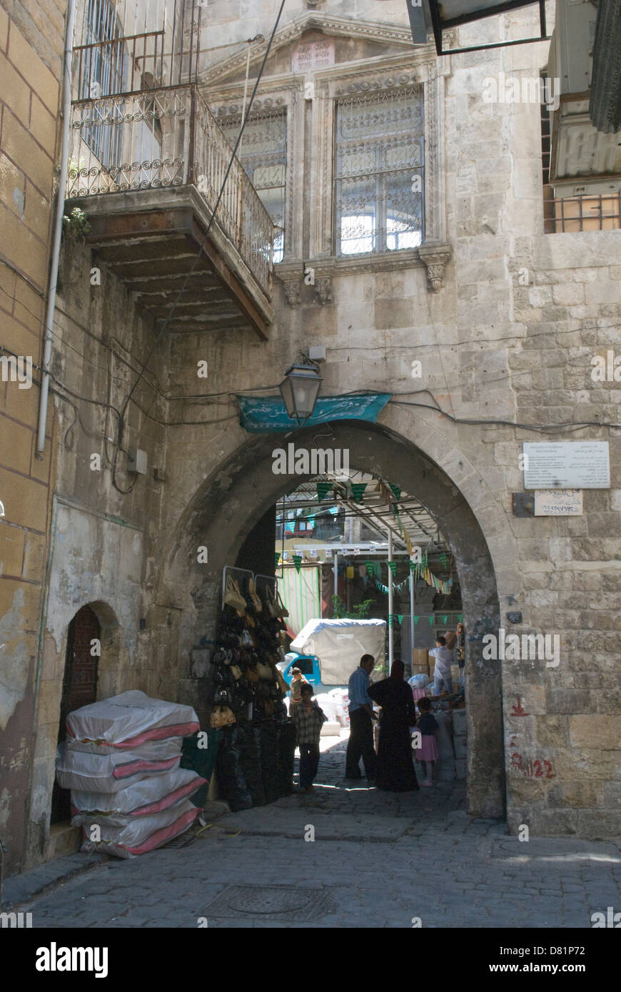 Aleppo, Siria. La gente in una strada sotto un arco di pietra nel centro della città vecchia, un sito Patrimonio Mondiale dell'UNESCO. Foto Stock