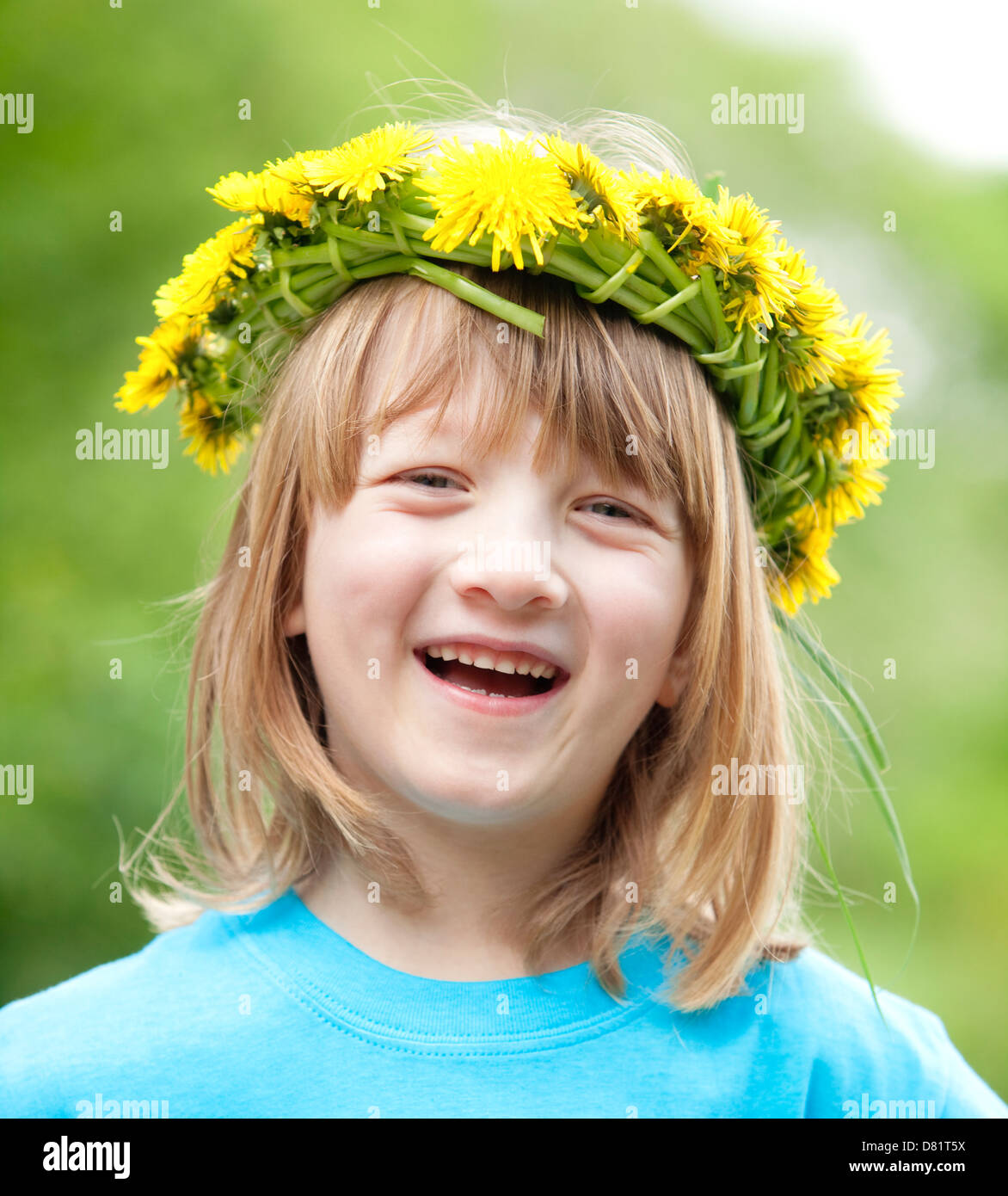 Ritratto di un ragazzo con lunghi capelli biondi che indossa una ghirlanda di fiori sorridenti Foto Stock