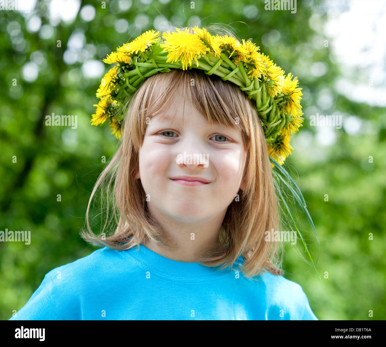 Ritratto di un ragazzo con lunghi capelli biondi che indossa una ghirlanda di fiori Foto Stock