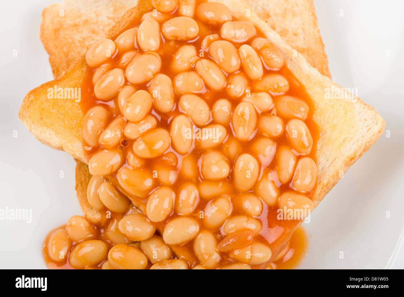 Fagioli su pane tostato - Fette di pane abbrustolito pane bianco, imburrato e guarnita con fagioli al forno. Semplice colazione britannica pasto. Foto Stock