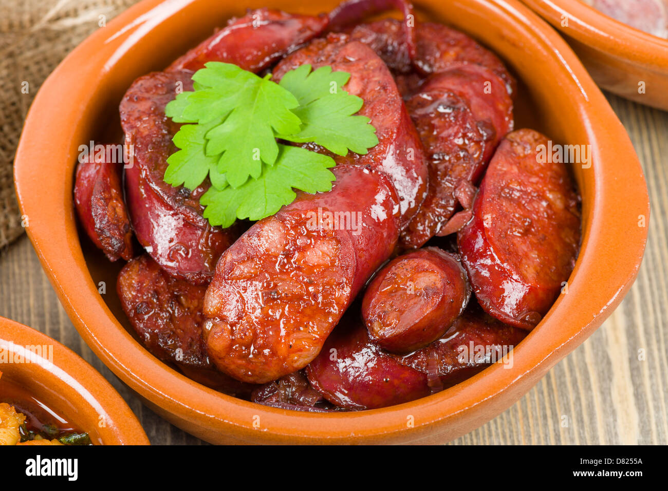 Il chorizo al vino (salsicce piccanti cotte nel vino rosso). Tapas tradizionali spagnole piatto. Foto Stock