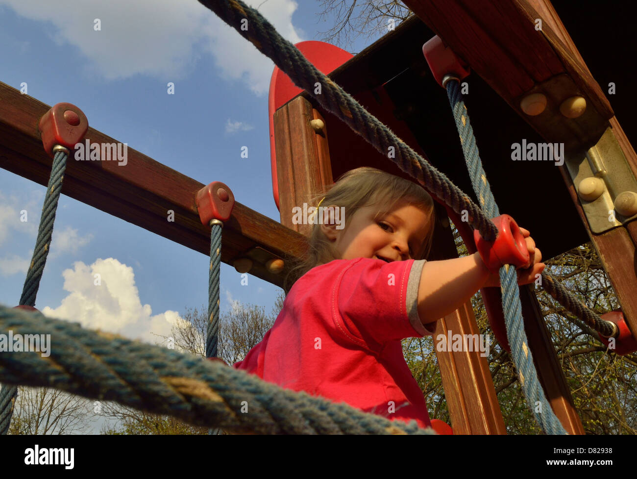 2 anno vecchia ragazza camminare sulla giungla della palestra presso il parco giochi sorridente Foto Stock