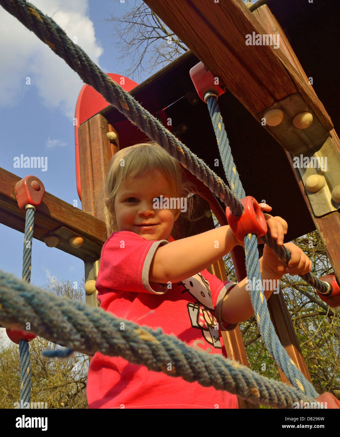 2 anno vecchia ragazza camminare sulla giungla della palestra presso il parco giochi sorridente Foto Stock