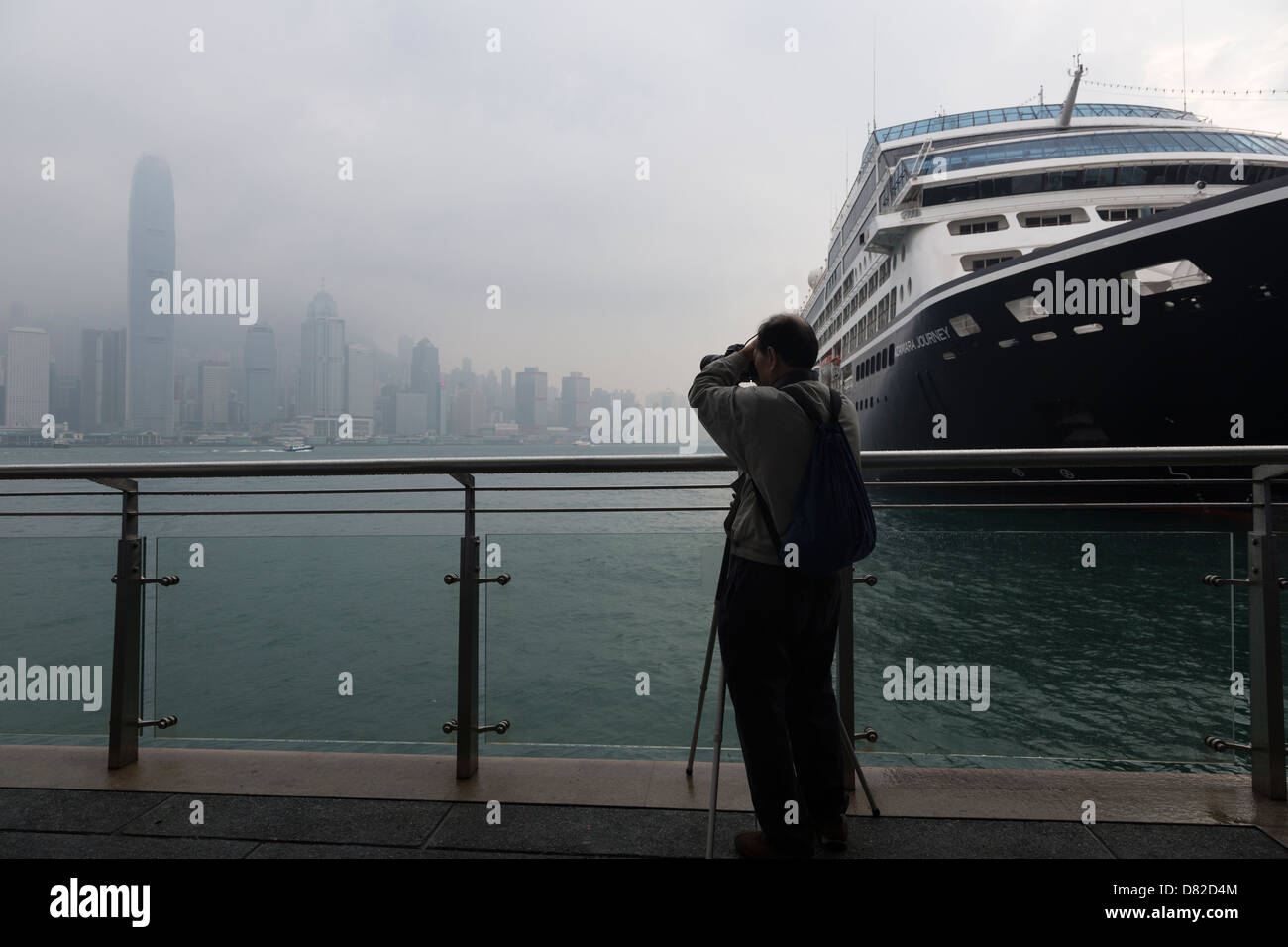 Fotografo di scattare le foto della skyline di Hong Kong accanto a una grande nave da crociera Foto Stock