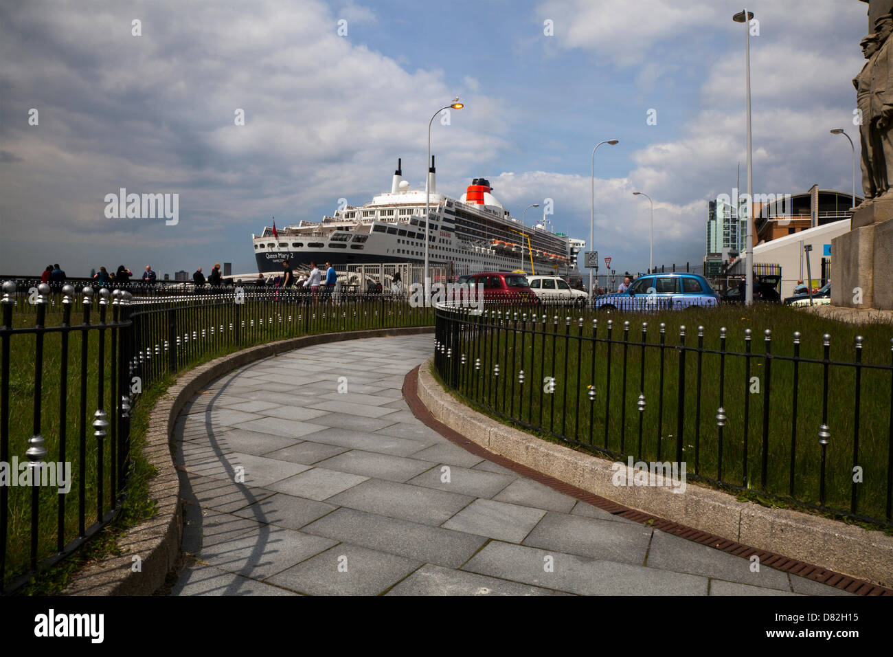 Liverpool, Regno Unito il 17 maggio 2013. La nave da crociera il terminale dove il passeggero luixury nave registrata in Bermuda Liner RMS Queen Mary 2 ormeggiato sulla sua visita alla città. Il Liverpool Cruise Terminal è un 350-metro-lunga struttura galleggiante situato sul fiume Mersey consentendo grandi navi da crociera per visitare senza inserire il dock chiuso o sistema di ormeggio a metà fiume e i passeggeri di gara a terra. Il terminale è stato ufficialmente inaugurato il 21 Settembre 2007 da Sua Altezza Reale il Duca di Kent quando la Queen Elizabeth 2 ormeggiate presso il terminale. Foto Stock
