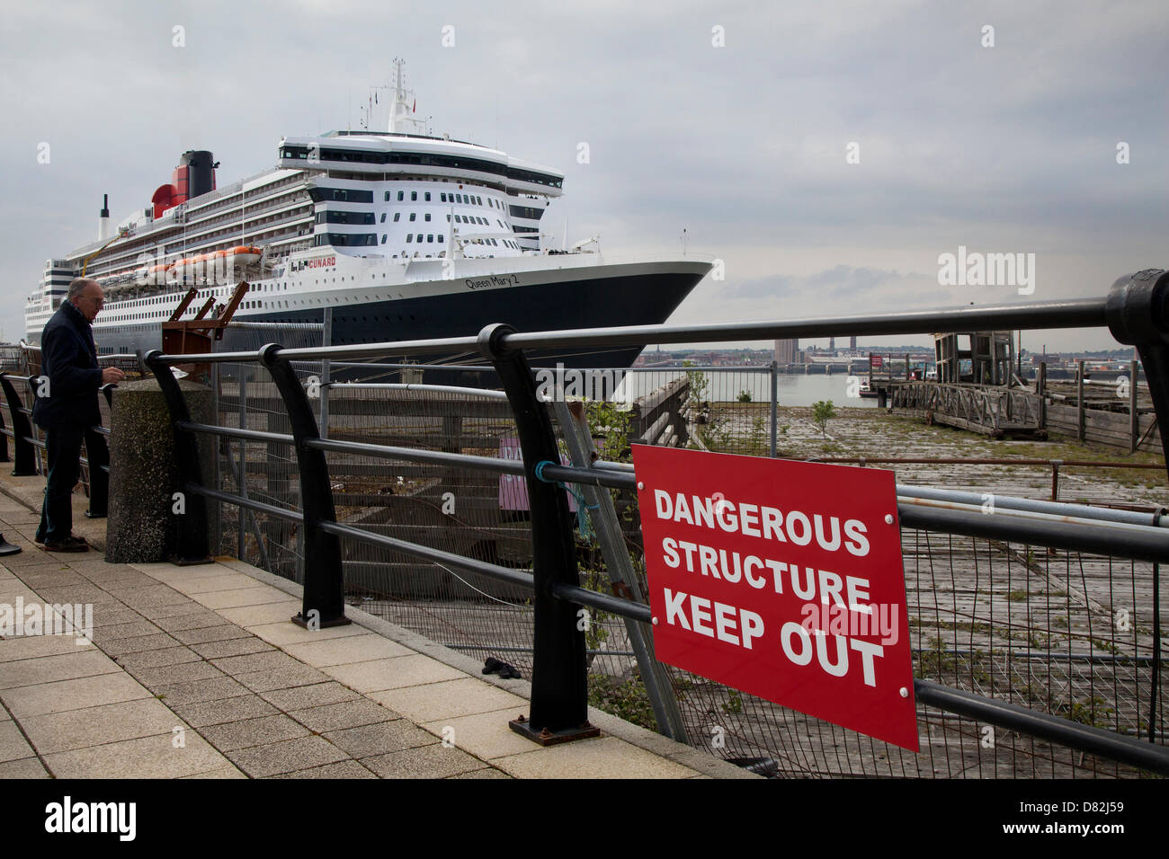 Liverpool, Regno Unito il 17 maggio 2013. Vecchio dock & struttura pericolose cartello in crociera il terminale dove la nave passeggeri registrati in Bermuda Liner RMS Queen Mary 2 ormeggiato sulla sua visita alla città. Il Liverpool Cruise Terminal di Princes Parade è un 350-metro-lunga struttura galleggiante situato sul fiume Mersey consentendo grandi navi da crociera per visitare senza inserire il dock chiuso o sistema di ormeggio a metà fiume e i passeggeri di gara a terra. Credito: Mar fotografico / Alamy Live News Foto Stock