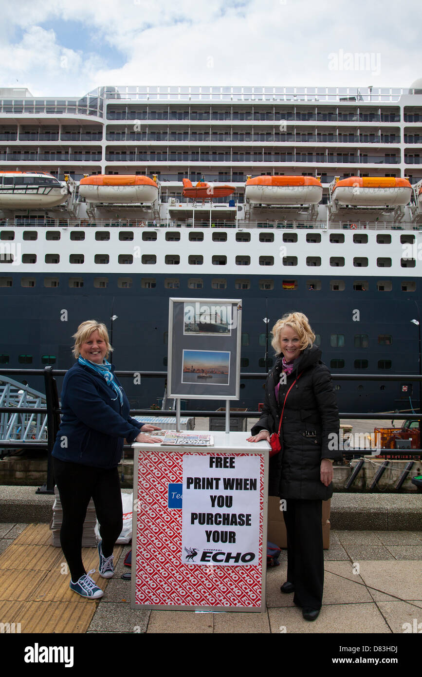 Liverpool, Regno Unito il 17 maggio 2013. Anne Jones & Julie Mallows vendita di Liverpool Echo in crociera il terminale in cui la camicia RMS Queen Mary 2 ormeggiato sulla sua visita alla città. Il Liverpool Cruise Terminal è un 350-metro-lunga struttura galleggiante situato sul fiume Mersey consentendo grandi navi da crociera per visitare senza inserire il dock chiuso o sistema di ormeggio a metà fiume e i passeggeri di gara a terra. Il terminale è stato ufficialmente inaugurato il 21 Settembre 2007 da Sua Altezza Reale il Duca di Kent quando la Queen Elizabeth 2 ormeggiate presso il terminale. Credito: Mar fotografico / Alamy Live News Foto Stock