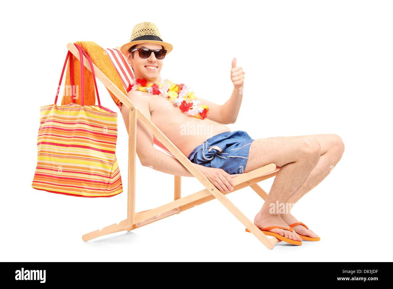 Felice giovane uomo su una sdraio sulla spiaggia dando pollice in alto  isolato su sfondo bianco Foto stock - Alamy