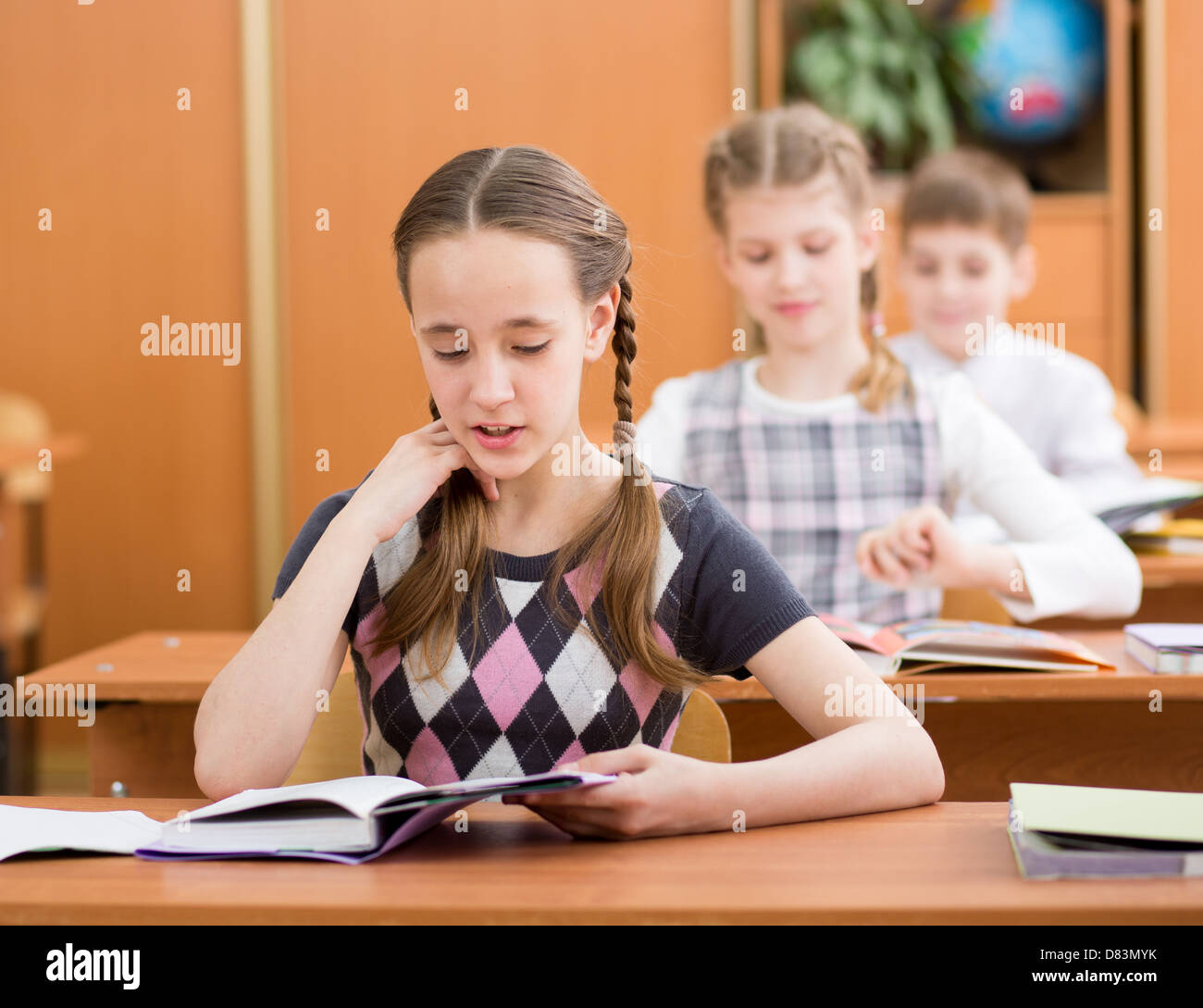 Schoolkids in aula. Ragazza attività di lettura ad alta voce a lezione. Foto Stock