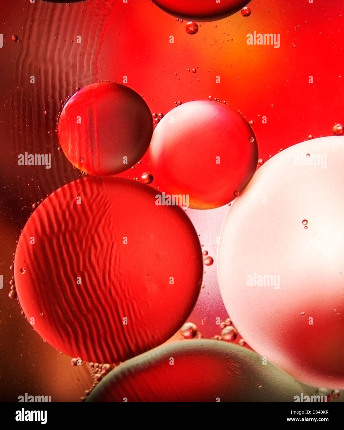 Un immagine astratta di olio su acqua in rosso Foto Stock