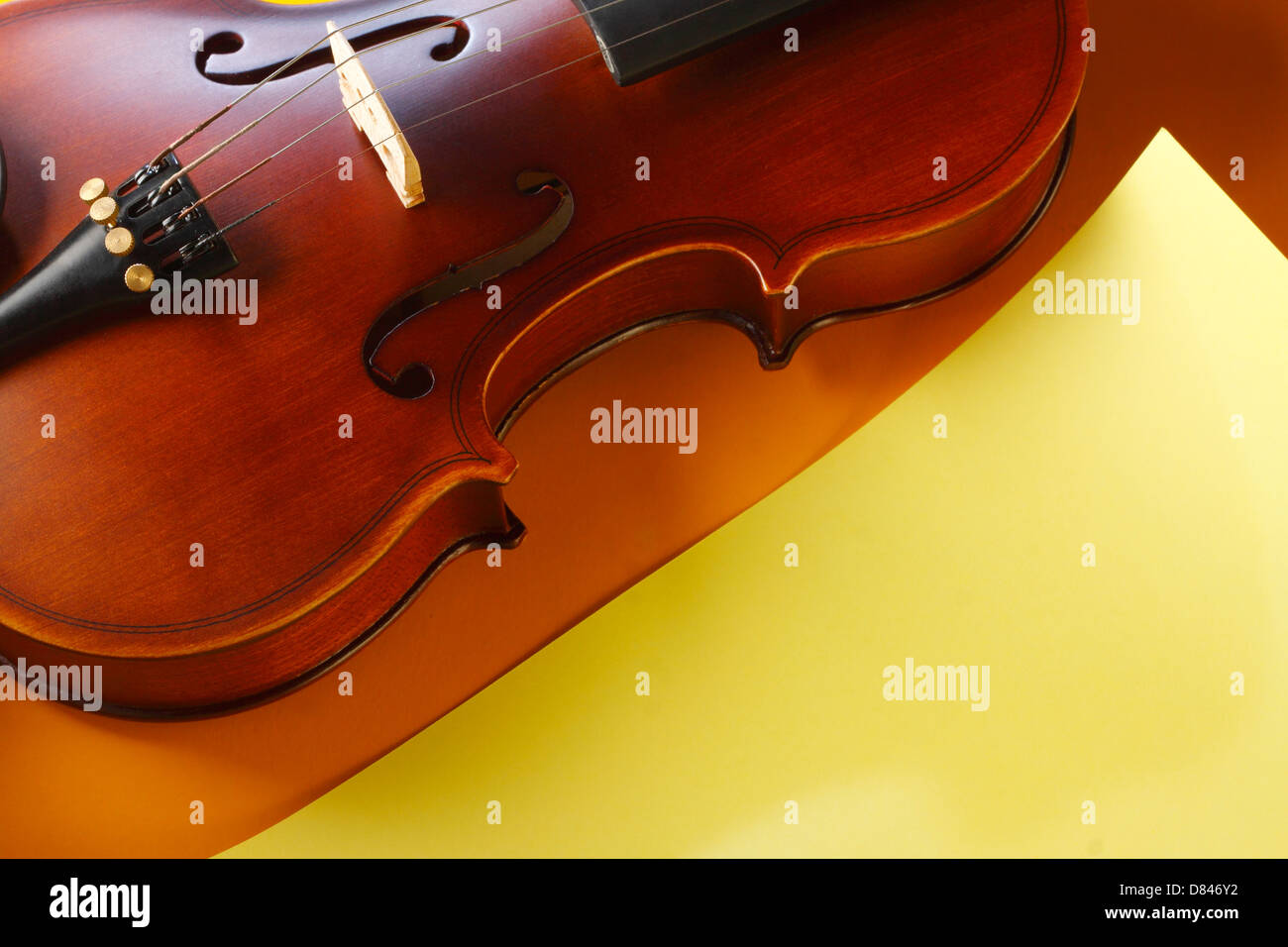 Violino e archetto con giallo nota carta su sfondo giallo Foto Stock