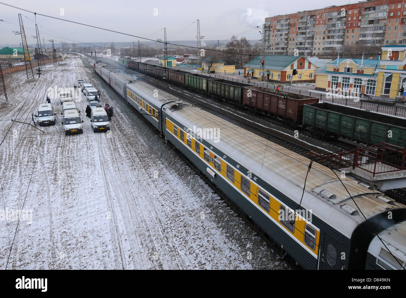 Treni, automobili e persone alla stazione ferroviaria in provinciale città russa. Inverno in Siberia, Russia Foto Stock