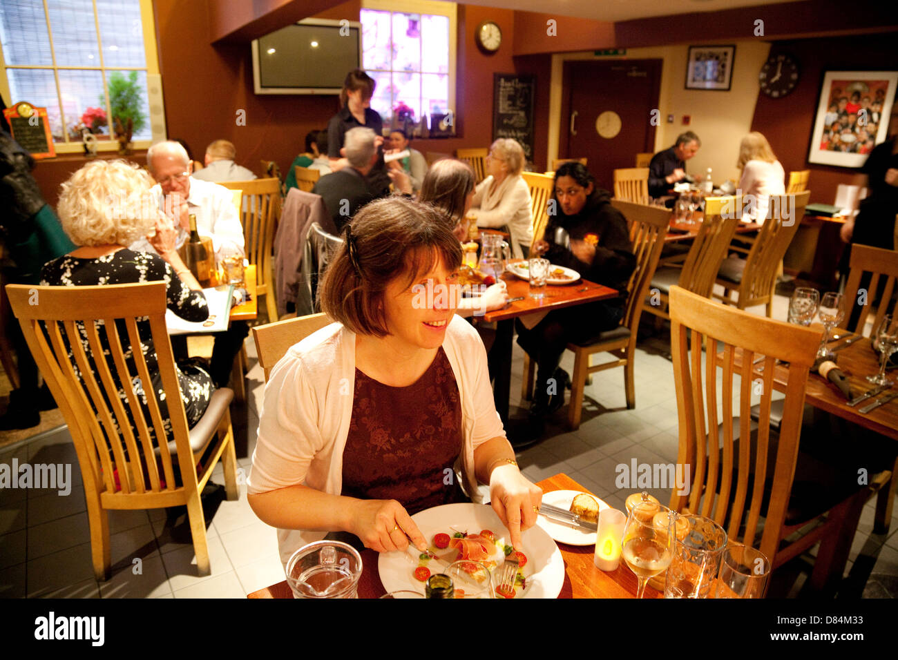 Una donna di mangiare il suo pasto serale, interni di Ate O'Clock ristorante, York, Yorkshire Regno Unito Foto Stock