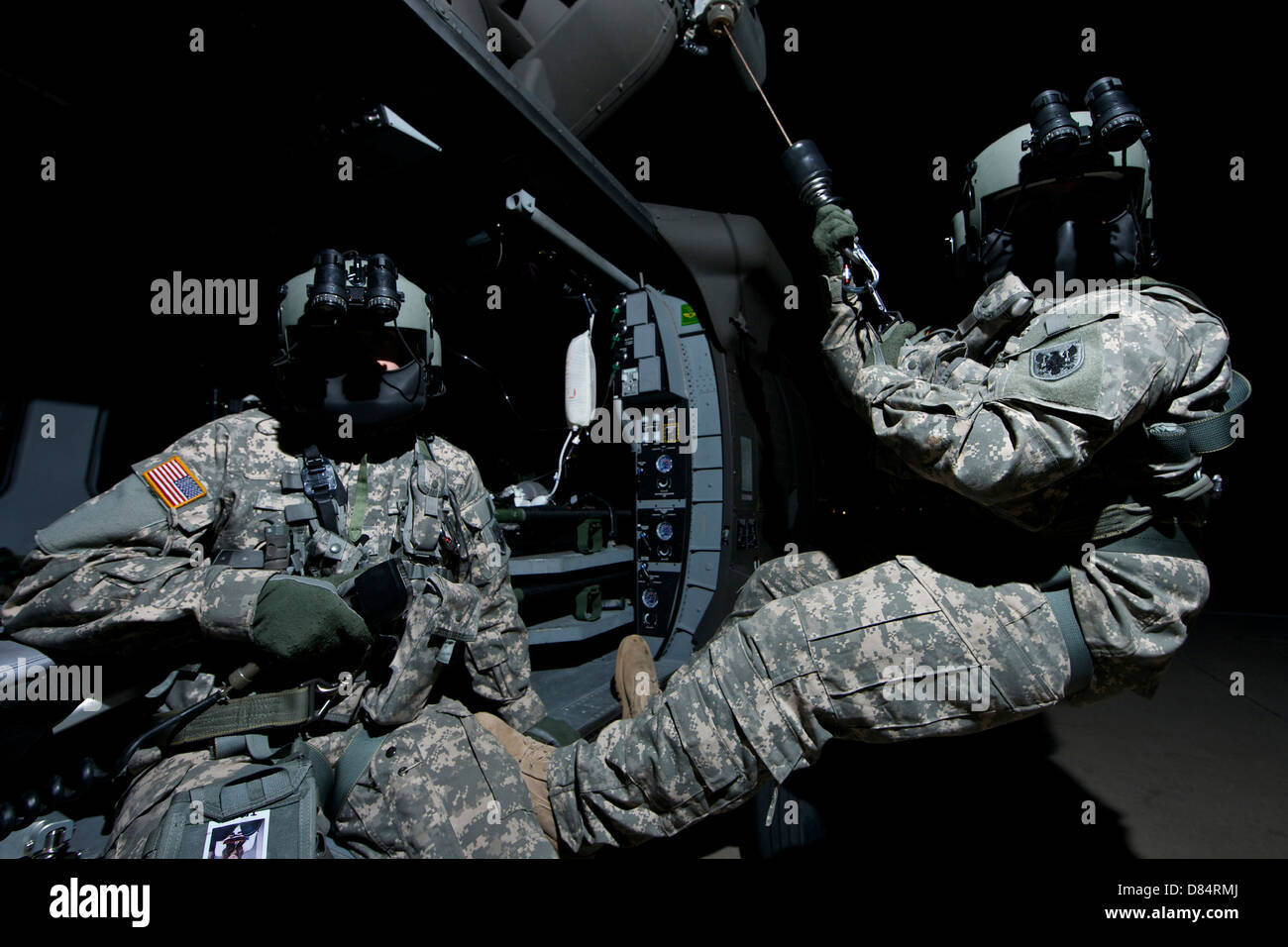 Capo equipaggio siede alla porta di un UH-60 Black Hawk medevac elicottero mentre il medic siede sul paranco. Foto Stock