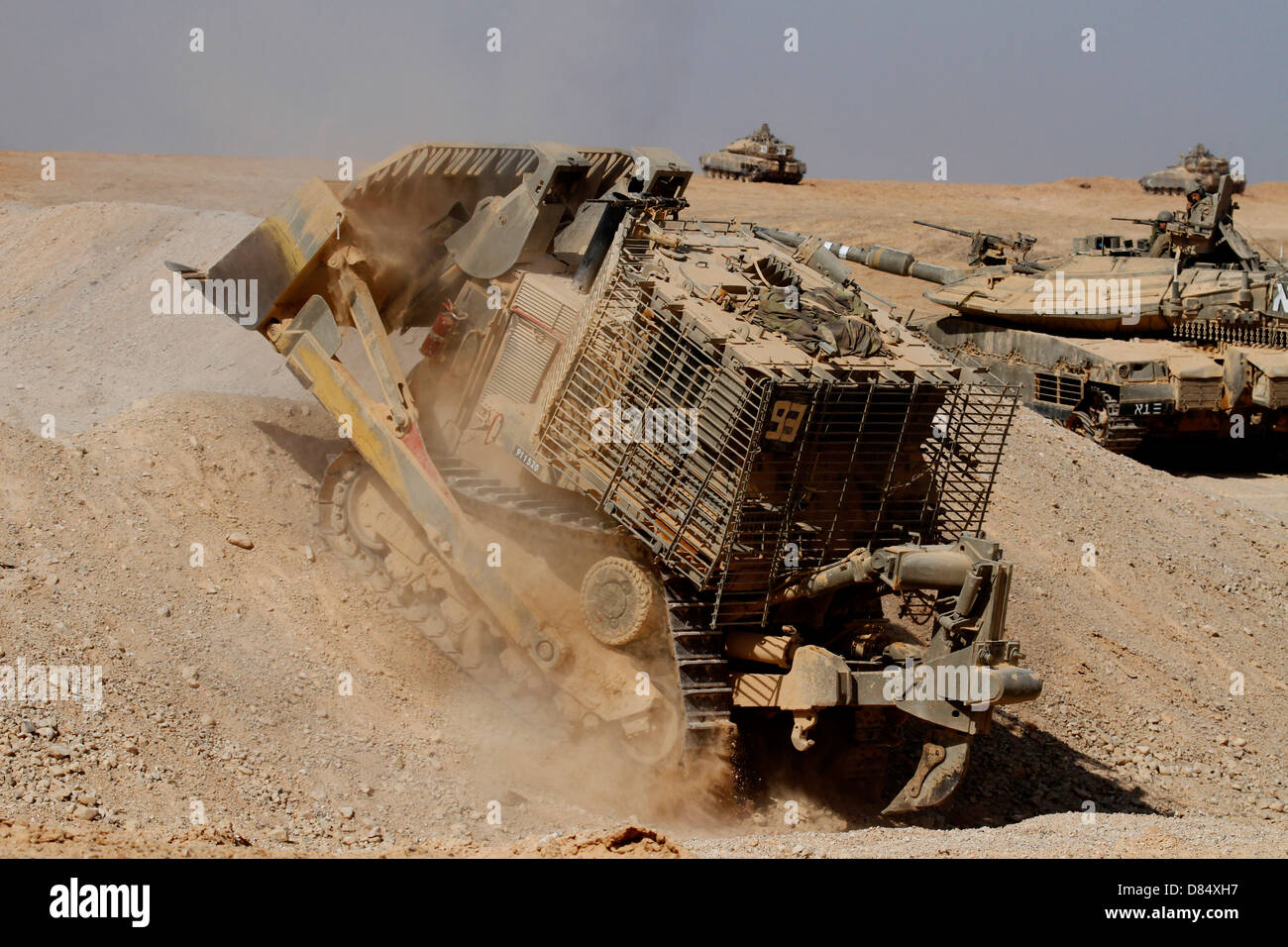 Un Israele Defense Force blindato di Caterpillar D-9 spianando la strada per Mark IV battaglia principale serbatoio durante un esercizio. Foto Stock