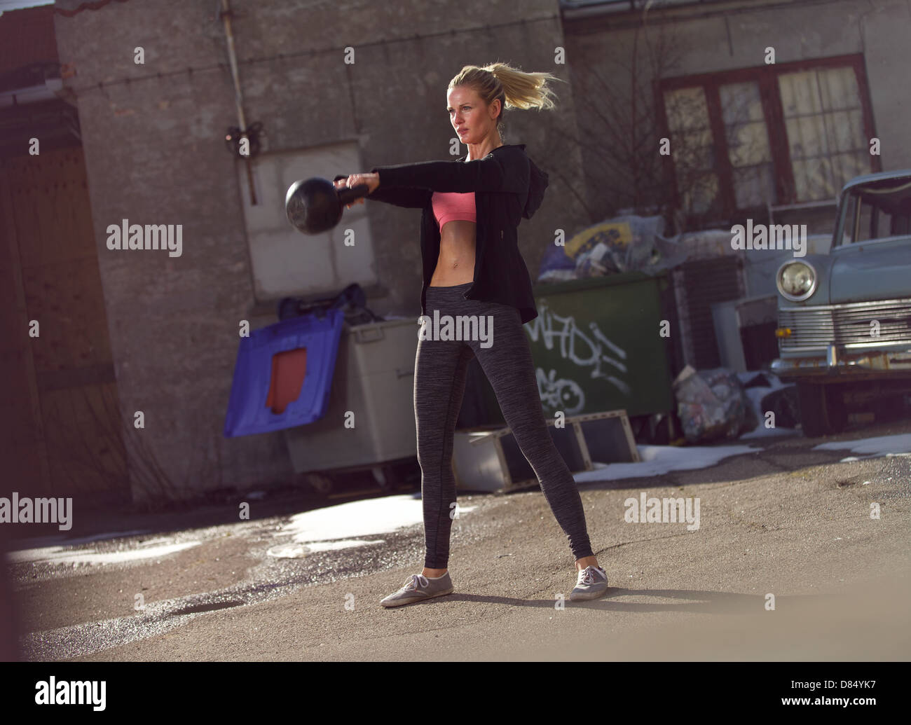 Giovane donna fitness facendo oscillare il kettlebell durante il training crossfit Foto Stock