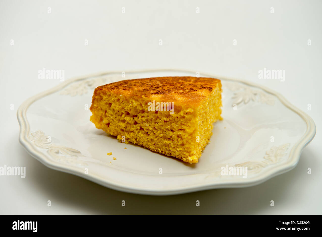 Una fetta di cornbread fatti in casa su una piastra bianca con sfondo bianco. Oklahoma, Stati Uniti d'America. Foto Stock