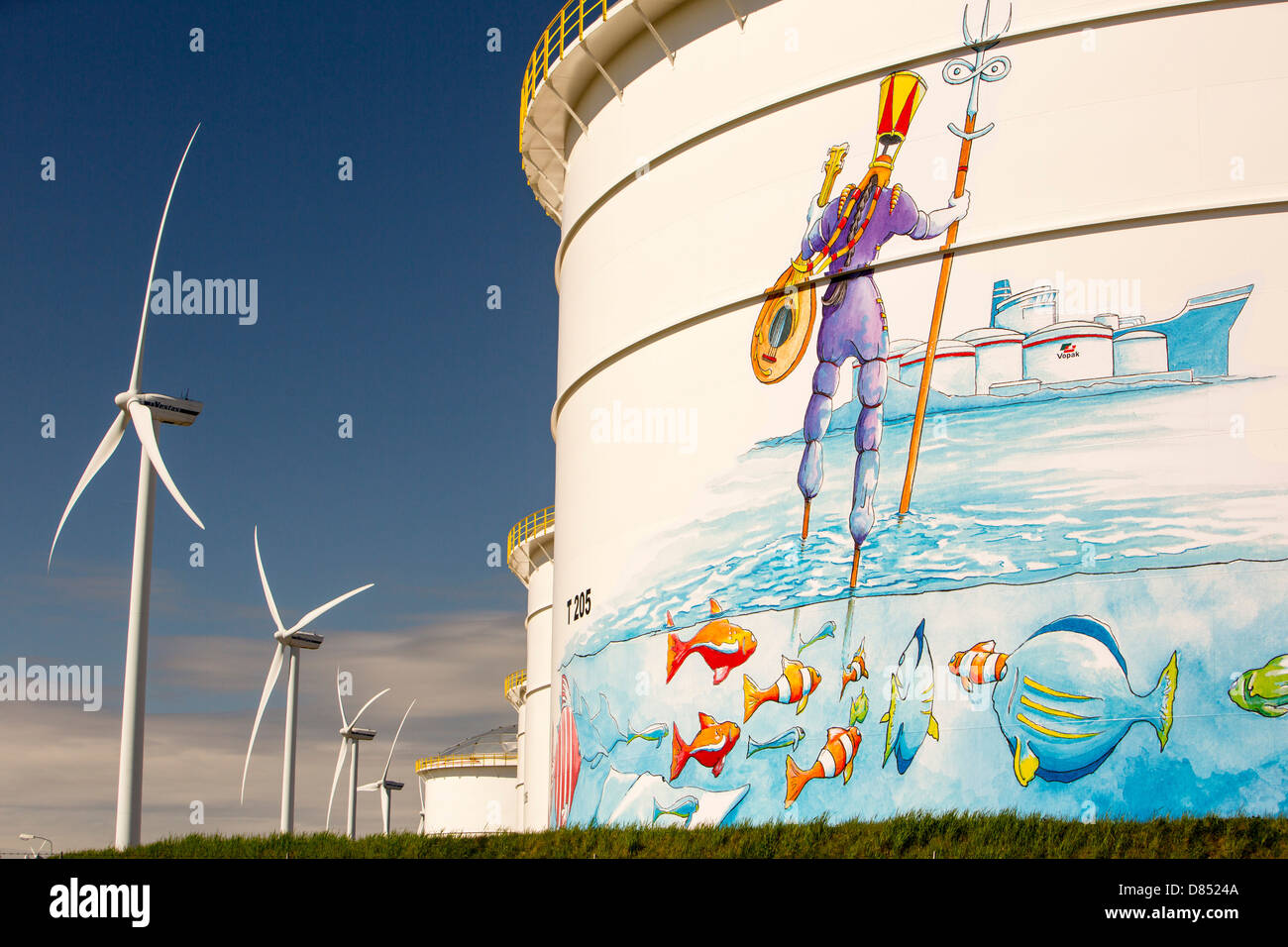 Il cambiamento climatico il cielo e l'inferno, un terminale petrolifero di Amsterdam, Paesi Bassi, con turbine eoliche che generano energia rinnovabile. Foto Stock
