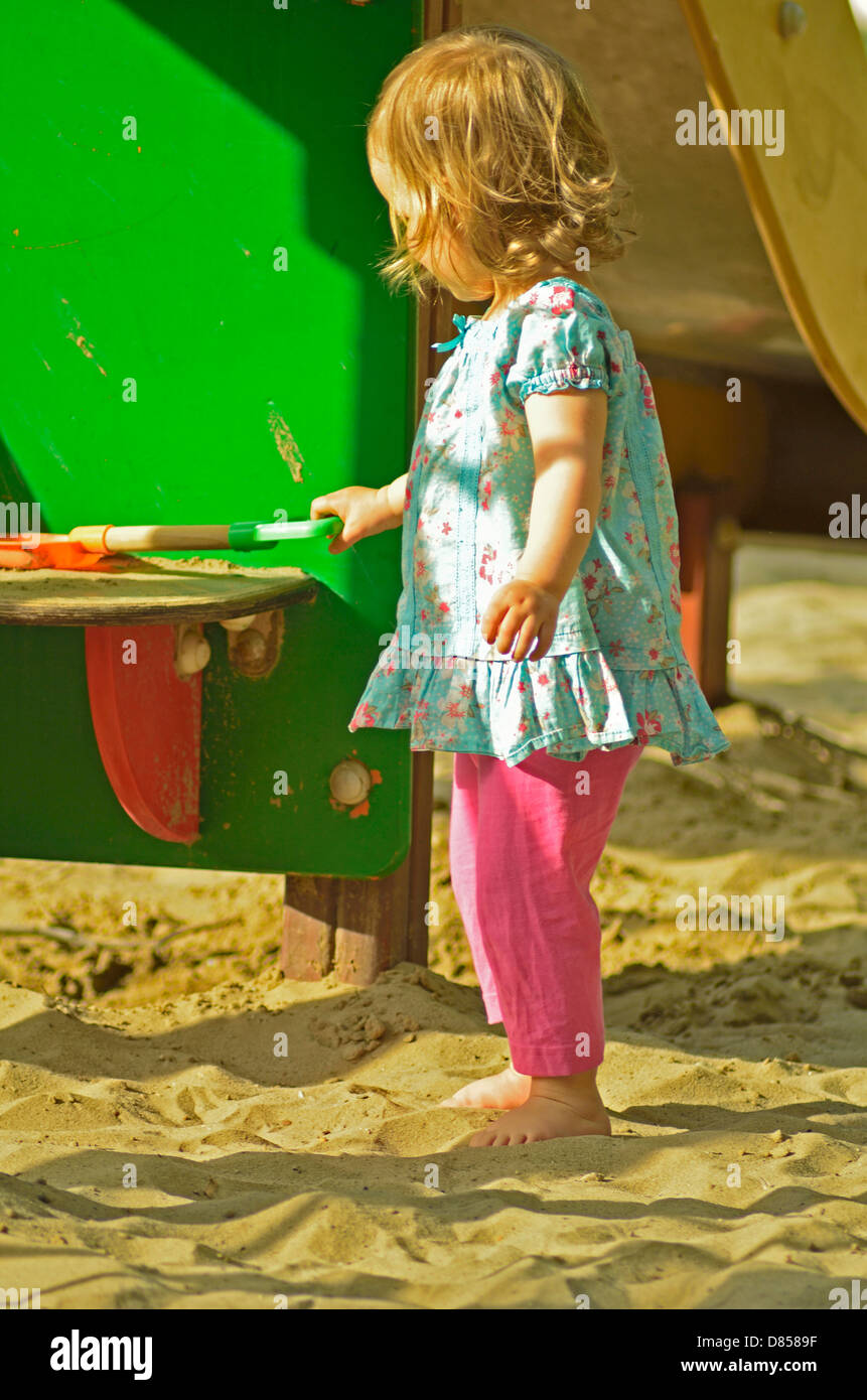 2 anni di bambina di giocare in un parco giochi Foto Stock