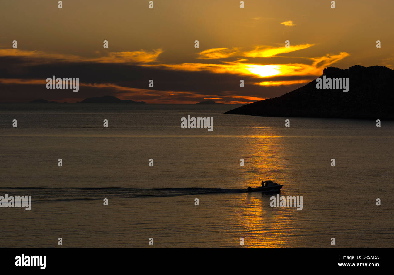 Golden arancione tramonto con riflessioni e barche da pesca, il Mare Egeo, Kalymnos, Grecia Foto Stock