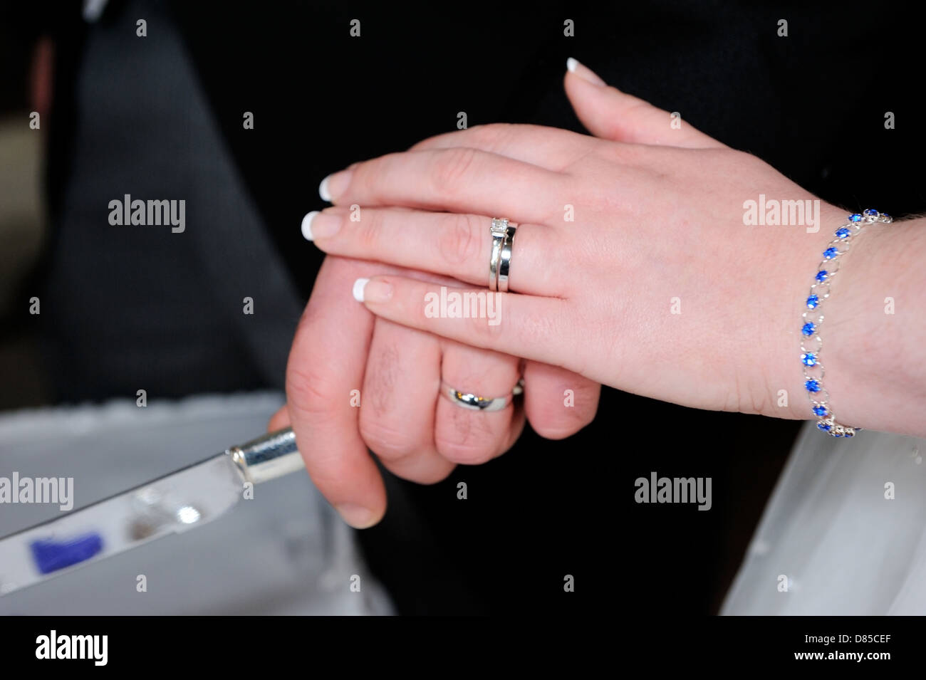 Primo piano della sposa e sposi mani torta di taglio Foto Stock