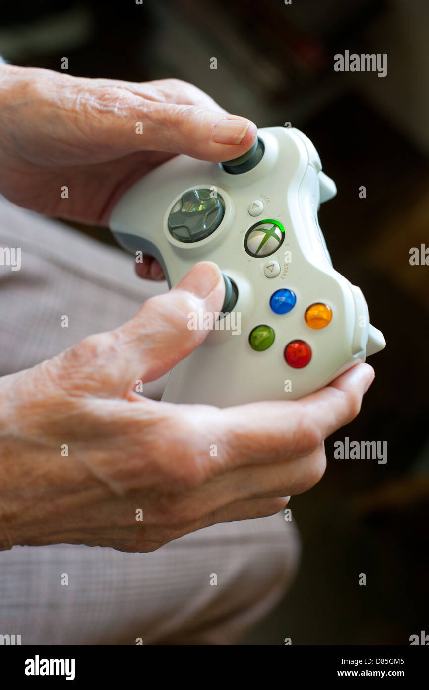 Una donna anziana utilizzando Xbox 360 gamepad Foto Stock