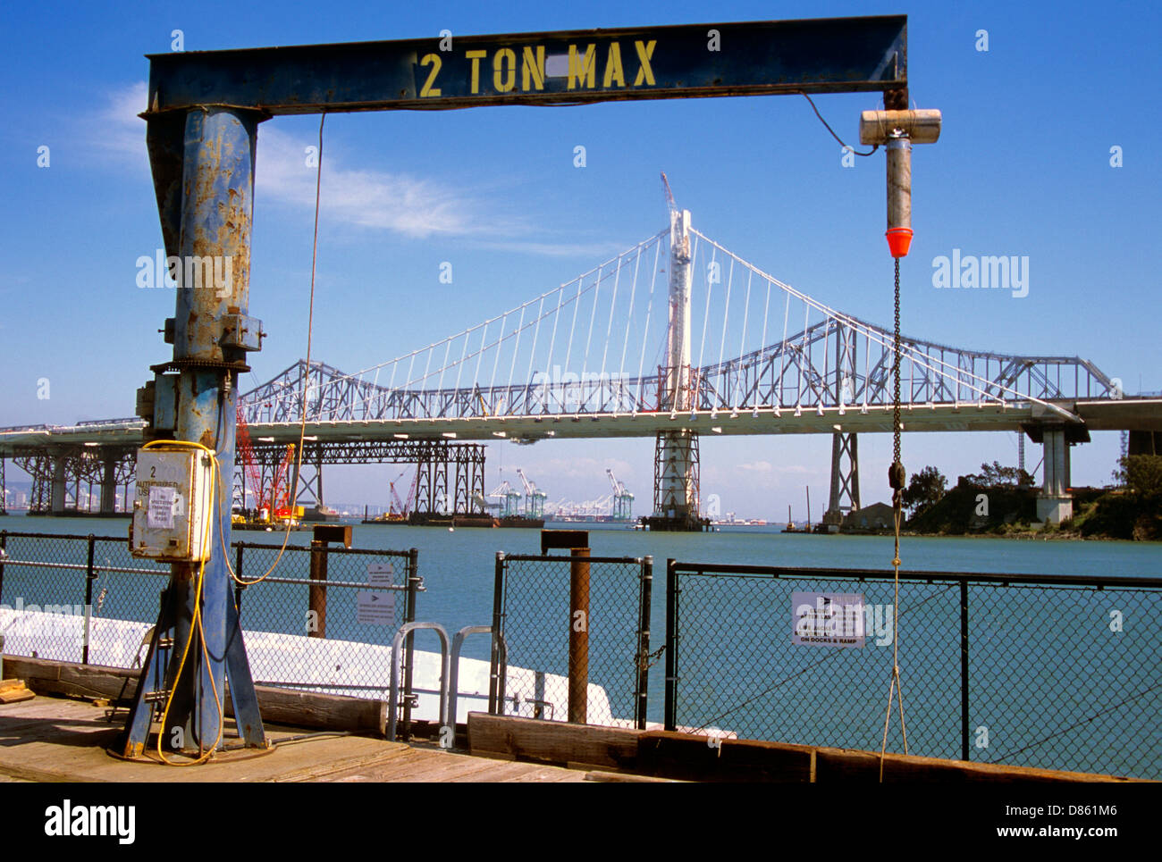 Visualizzare di nuovo il Bay Bridge costruzione dall'isola del tesoro dock con 2 ton molo gru in primo piano Foto Stock