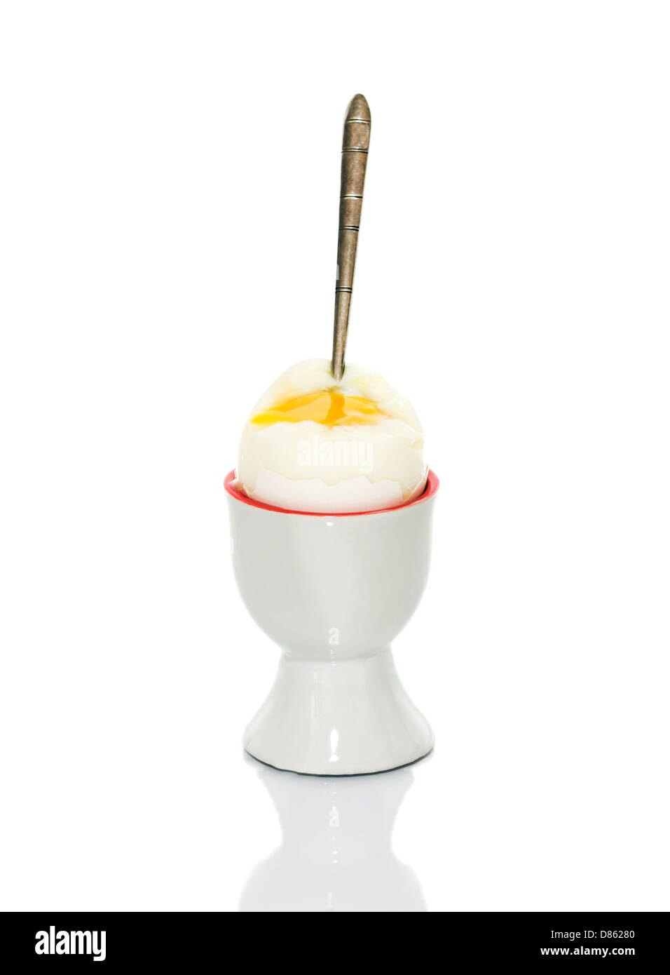 Supporto in ceramica per le uova con uovo e cucchiaio Foto Stock