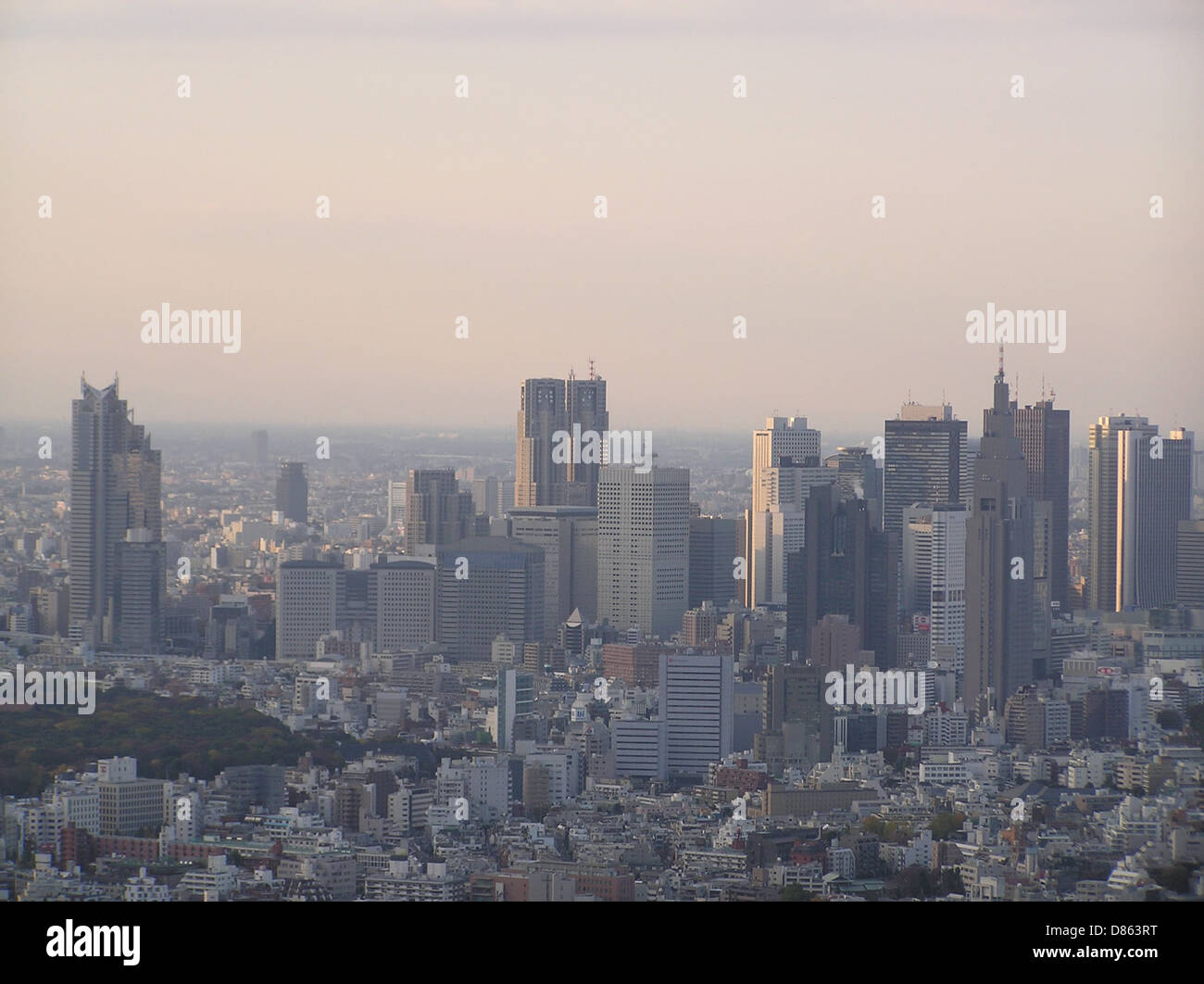 Il quartiere Shinjuku di Tokyo è conosciuto per il suo impressionante skyline, caratterizzato da numerosi grattacieli che ospitano uffici, centri commerciali e luoghi di intrattenimento. Questa fotografia del novembre 2003 cattura la vivacità architettonica di una delle aree urbane più trafficate di Tokyo. Foto Stock