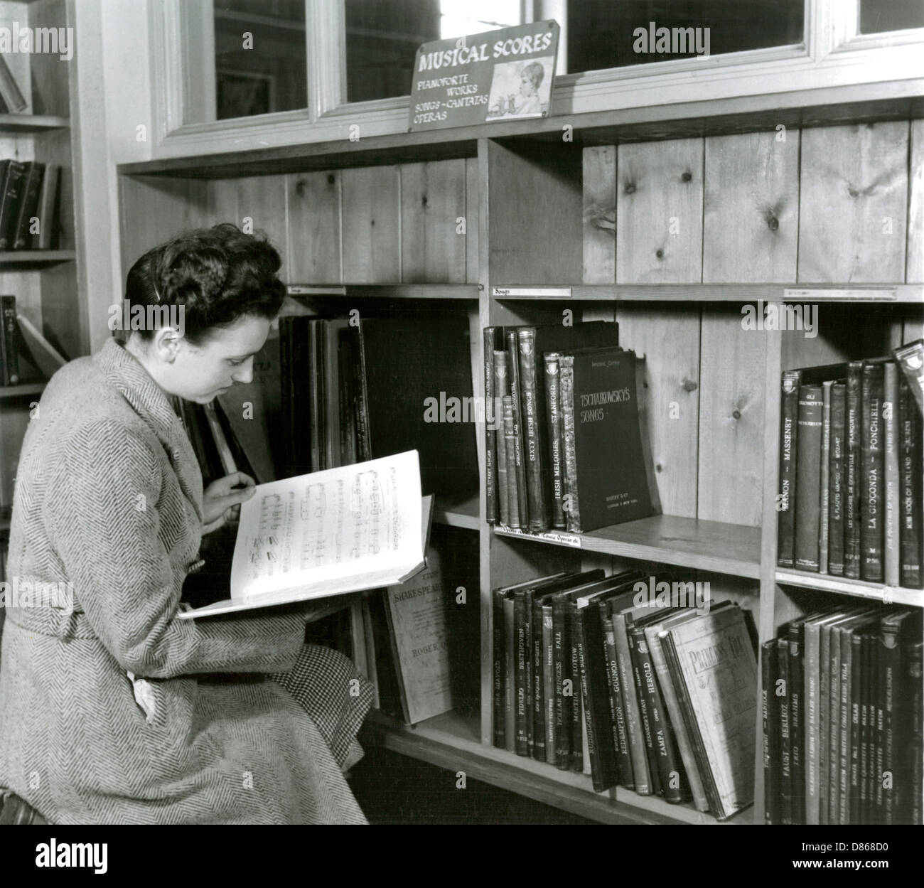 Lettura di una partitura in una libreria musicale Foto Stock