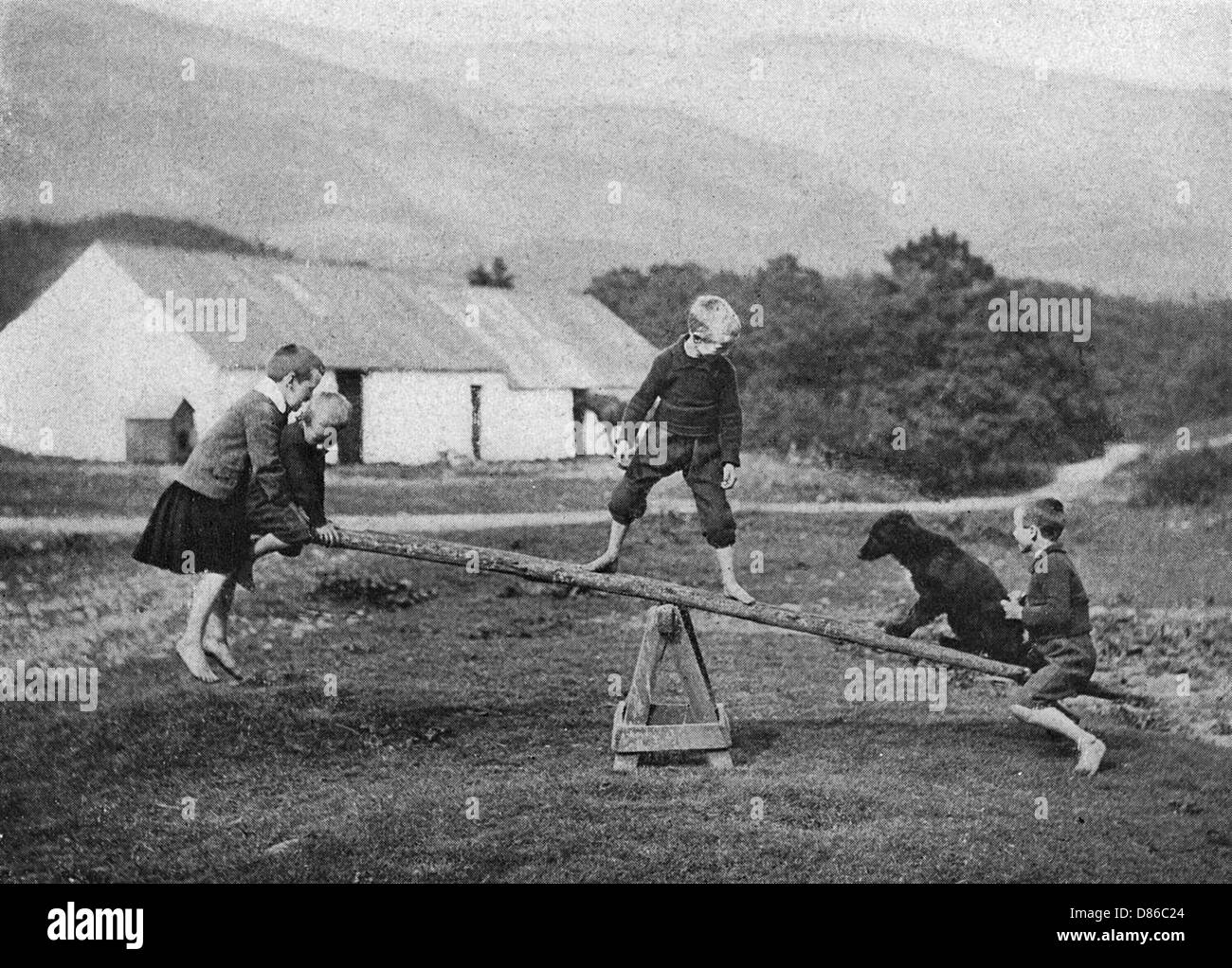 I bambini e un cane giocano su una seghetta Foto Stock