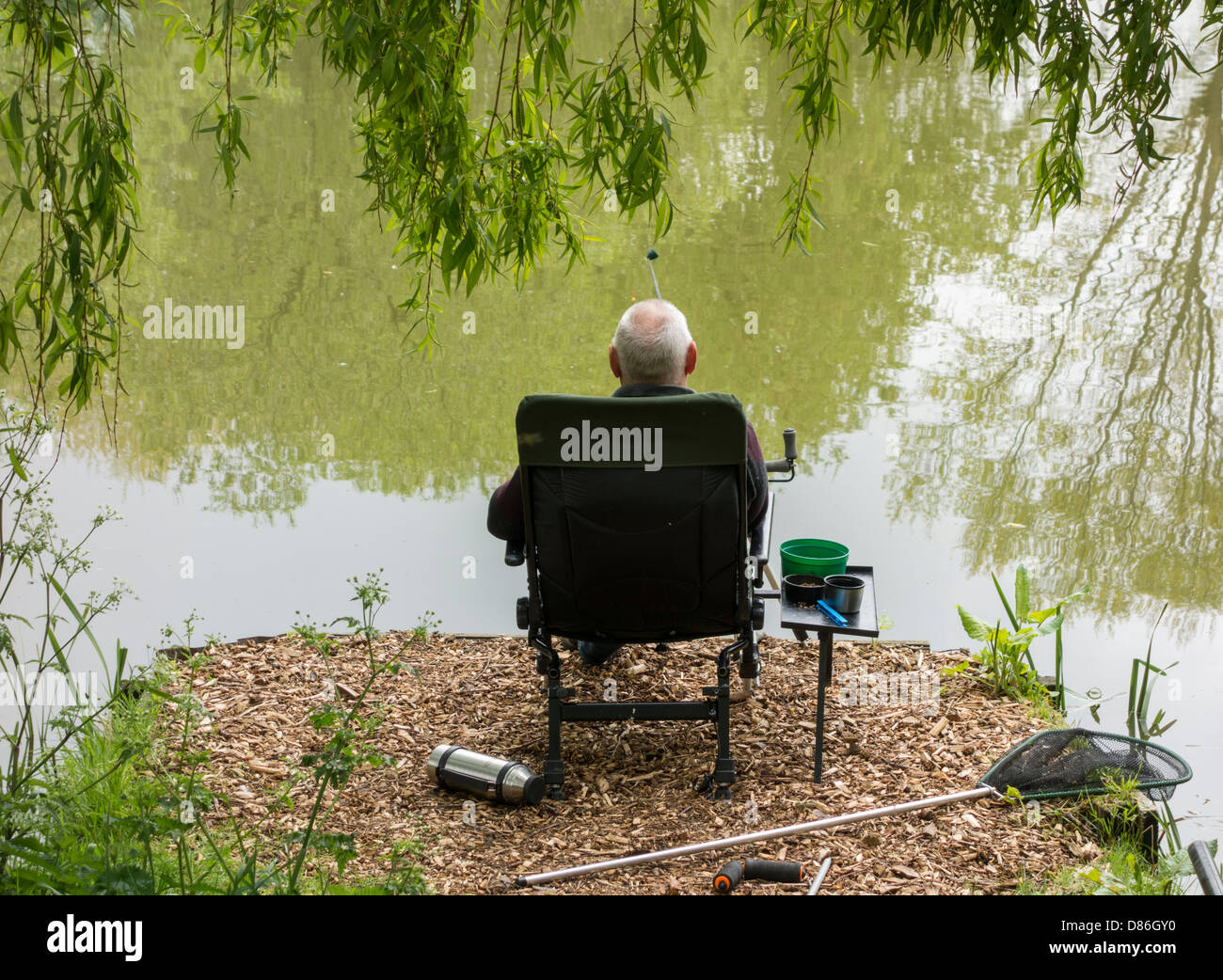 Uomo di Pesca nel laghetto Charltons in Billingham, Cleveland, England, Regno Unito Foto Stock