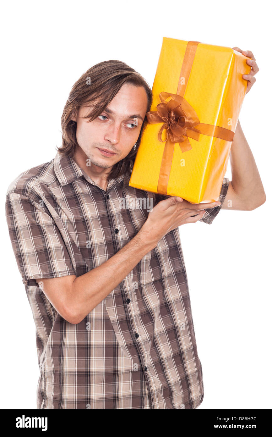 Curioso uomo giallo tenuta scatola regalo, isolati su sfondo bianco Foto Stock