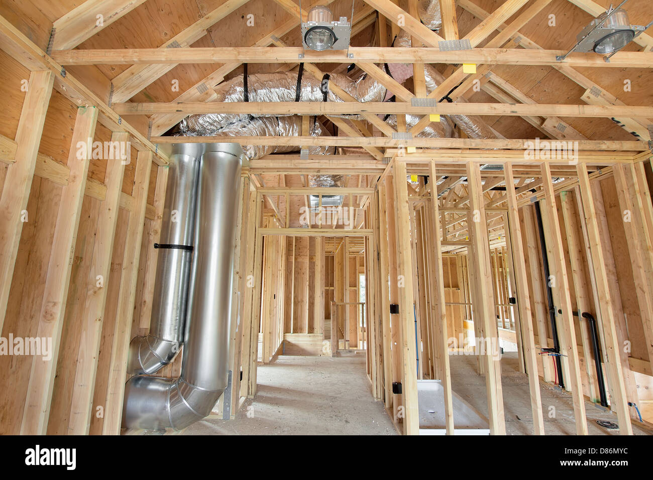 Nuova costruzione in casa con montanti in legno riscaldamento Framing sistema di raffreddamento condotto aria opere idrauliche ed elettriche di luce a soffitto lattine Foto Stock