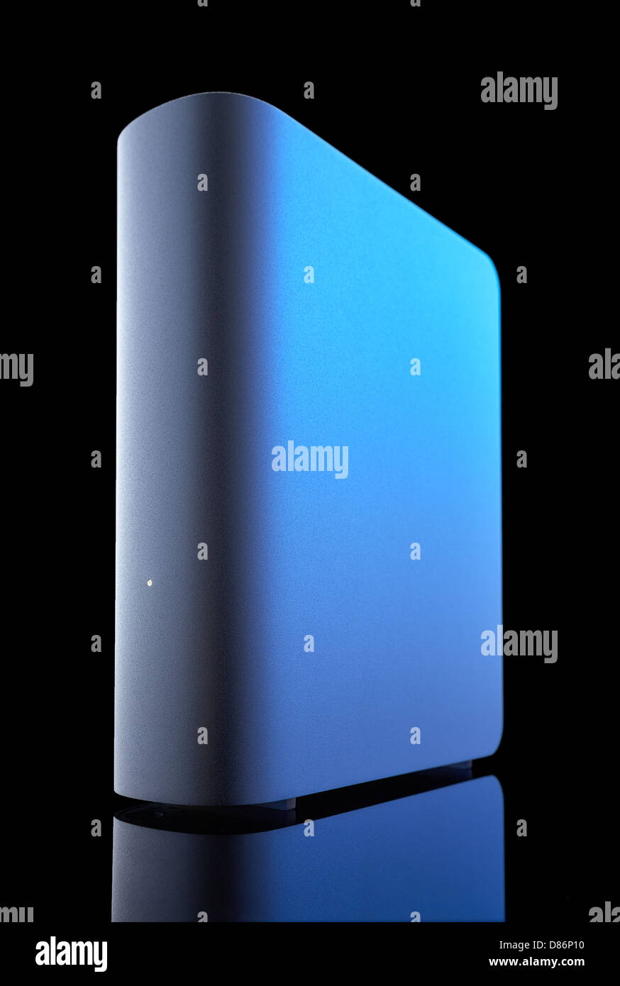 Grigio di un disco rigido esterno con evidenziazione blu su sfondo nero girato a basso angolo. La riflessione sul fondo. Foto Stock