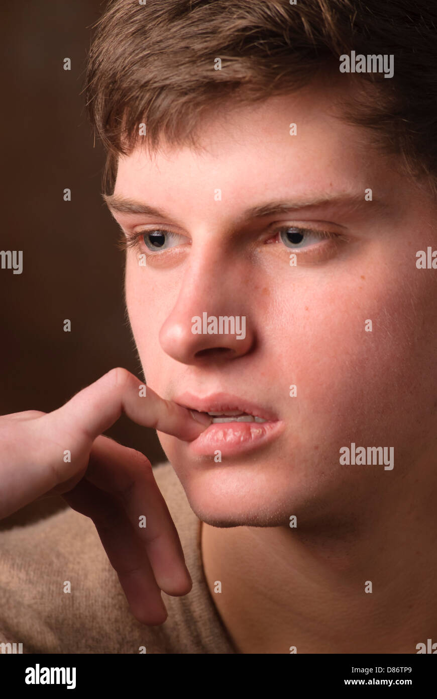 Teenager disturbato in attesa da solo in studio shot Foto Stock