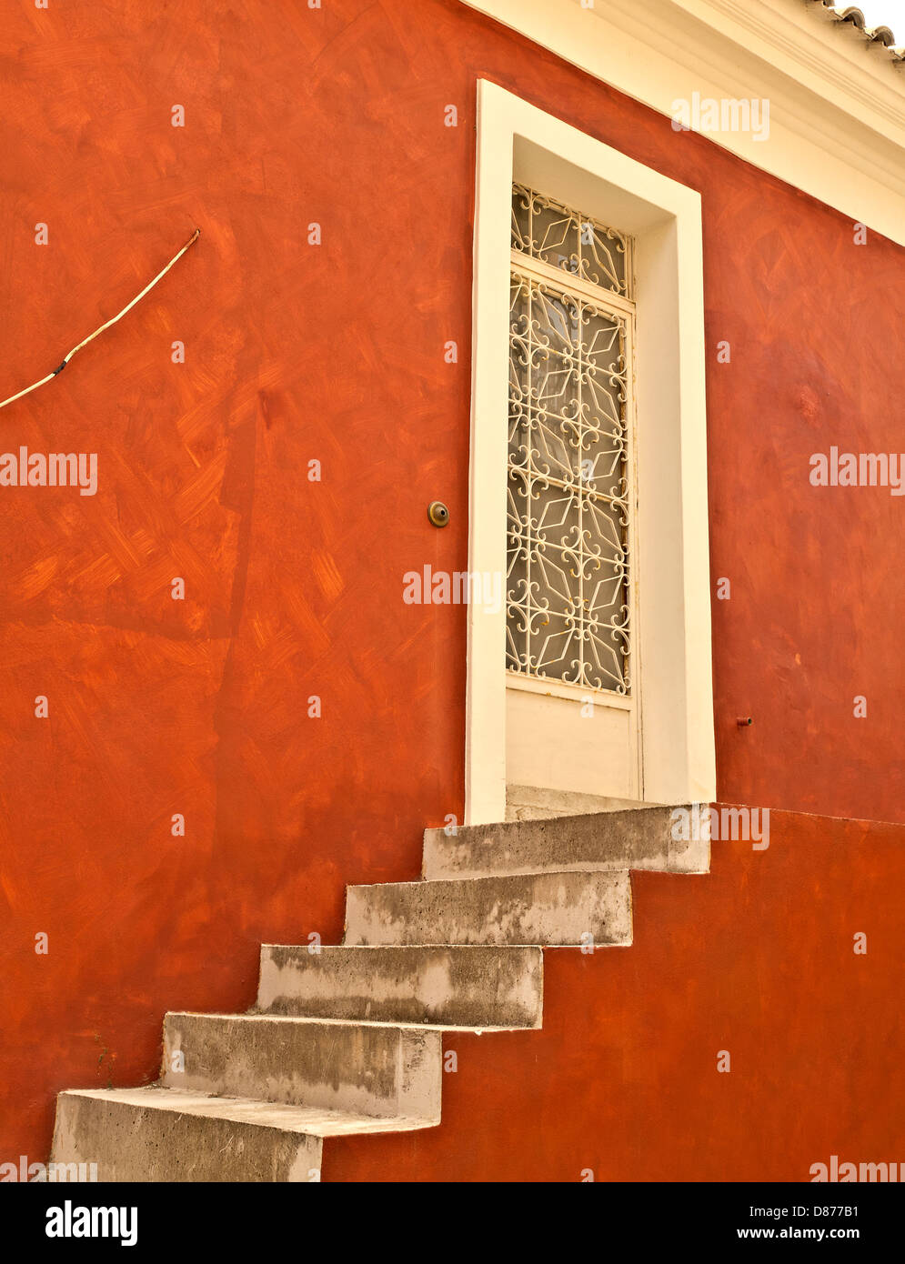 Il tradizionale rosso casa greca, aprire scalinata e artistica porta cablata, Lakones Village, Gorfu Island, Grecia Foto Stock