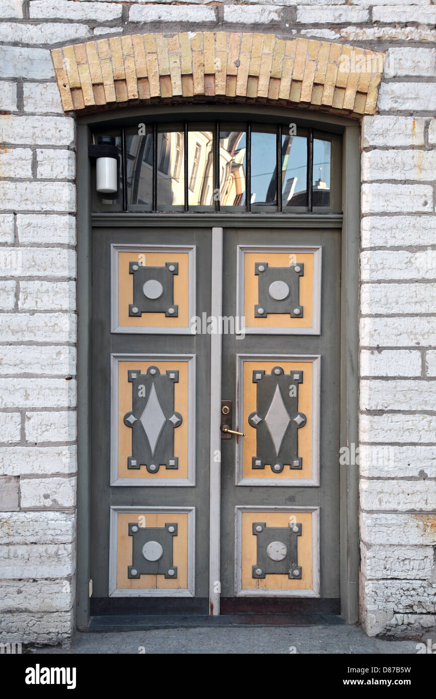 Verde porta in legno con decorazione colorata nella vecchia facciata di edificio. Tallinn, Estonia Foto Stock