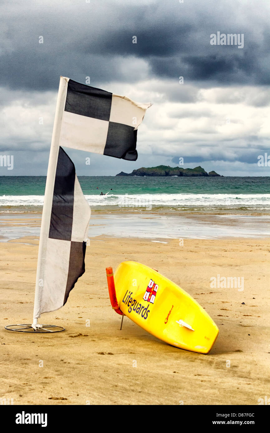 RNLI surfboard e spiaggia bandiera marcatore, Harlyn Bay, Cornwall, Inghilterra Foto Stock