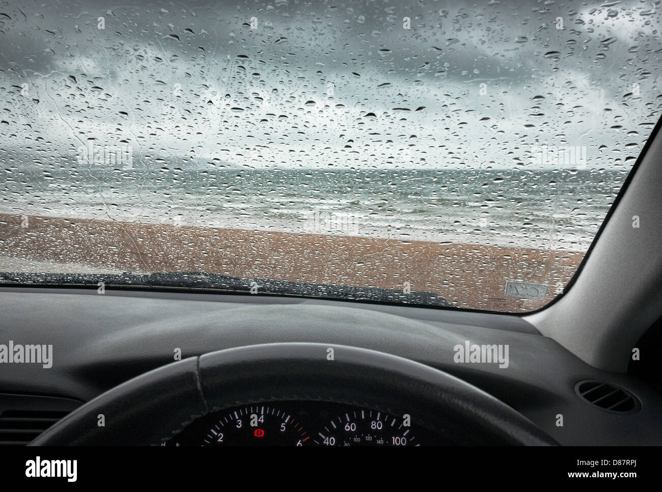 British seaside beach in un giorno di pioggia attraverso il parabrezza auto / parabrezza Foto Stock