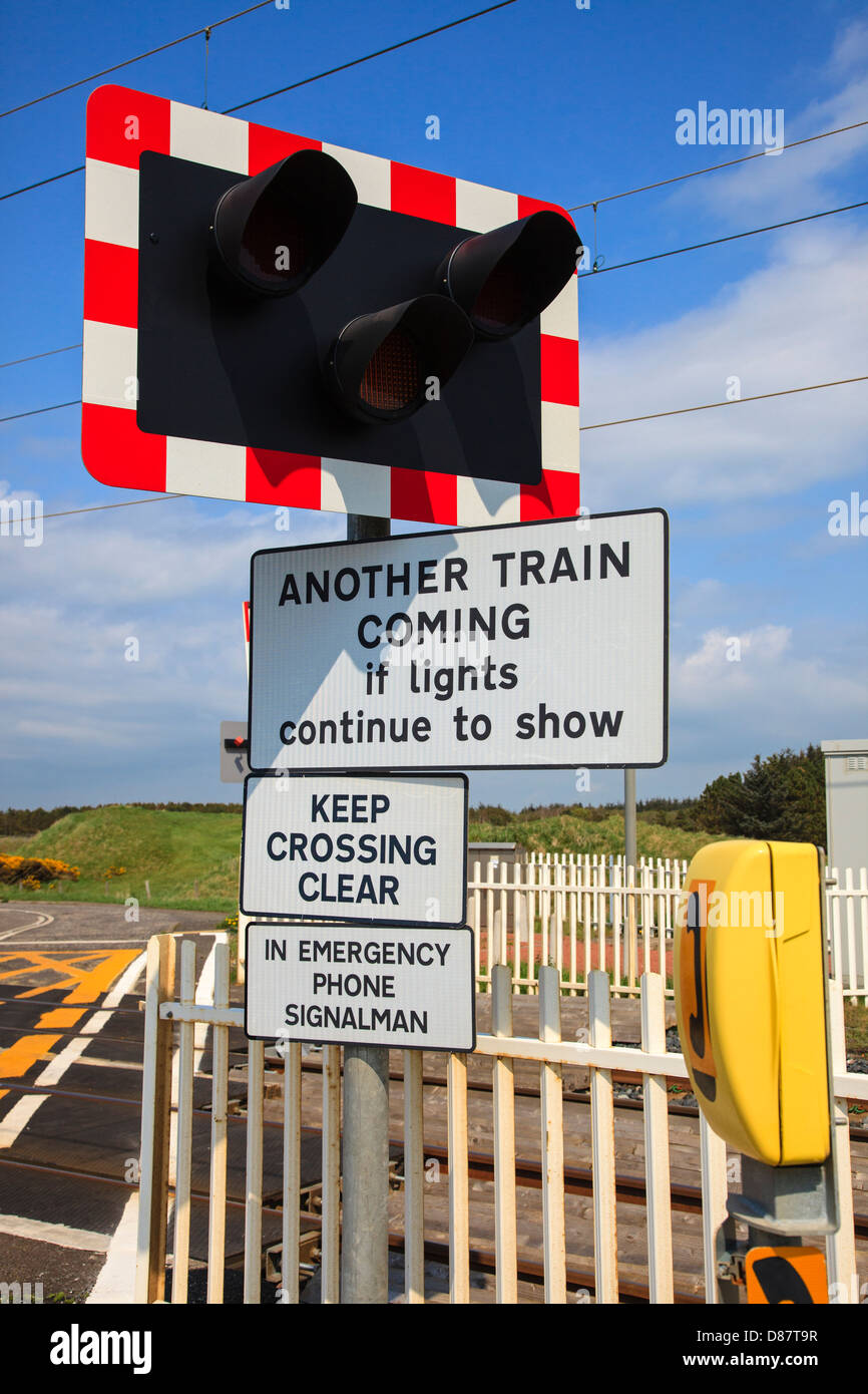 Cartelli di avvertimento. Per il controllo del traffico aereo luci e telefono di emergenza a lato di un incrocio ferroviario, vicino a Irvine, Ayrshire, in Scozia Foto Stock